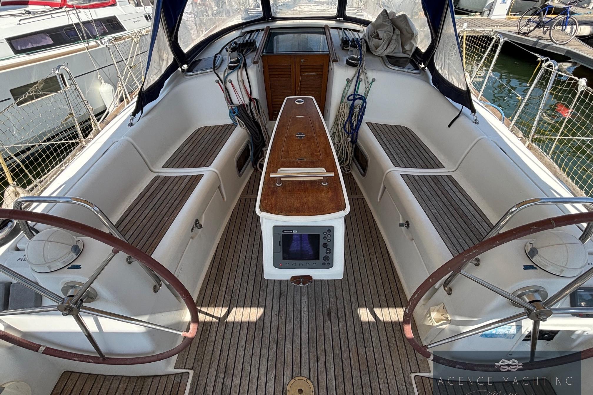 Cockpit of 2008 Beneteau Oceanis 40 sailboat with dual steering wheels and wooden seating.