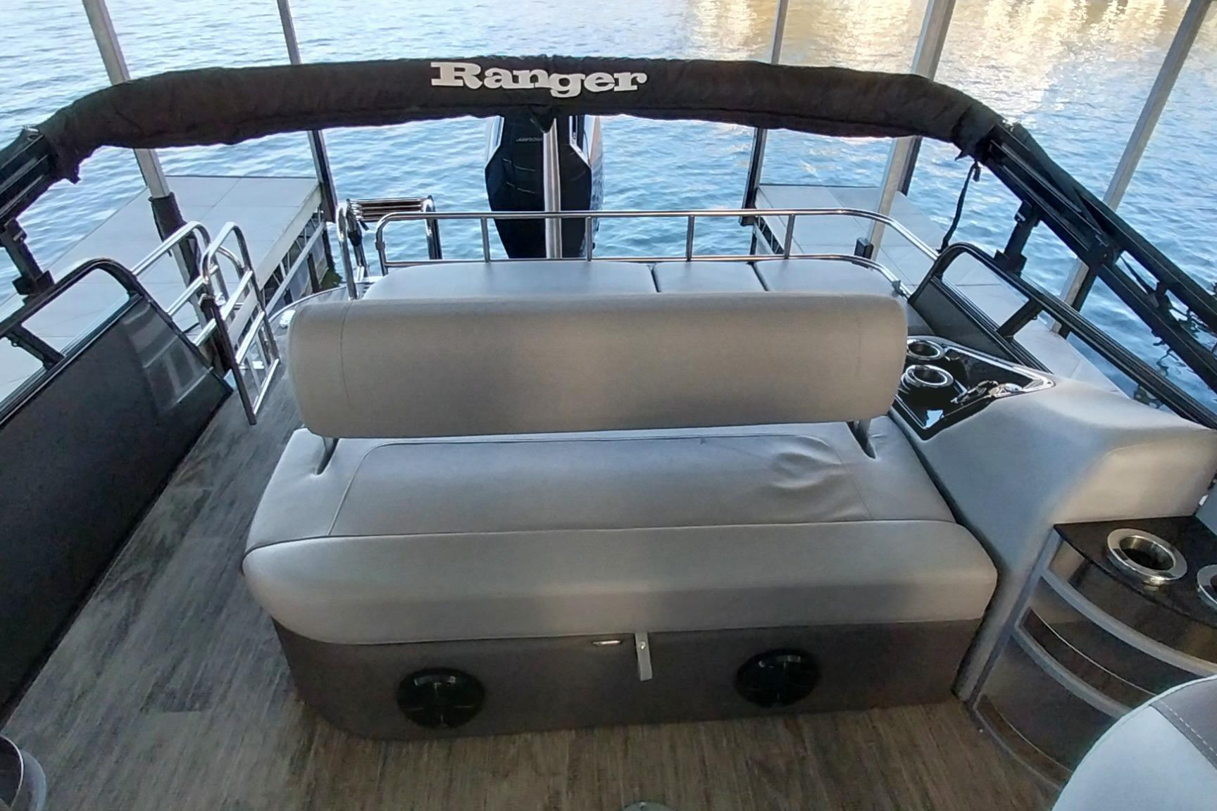 Interior of 2023 Ranger 2500LS boat with gray seating and cup holders.