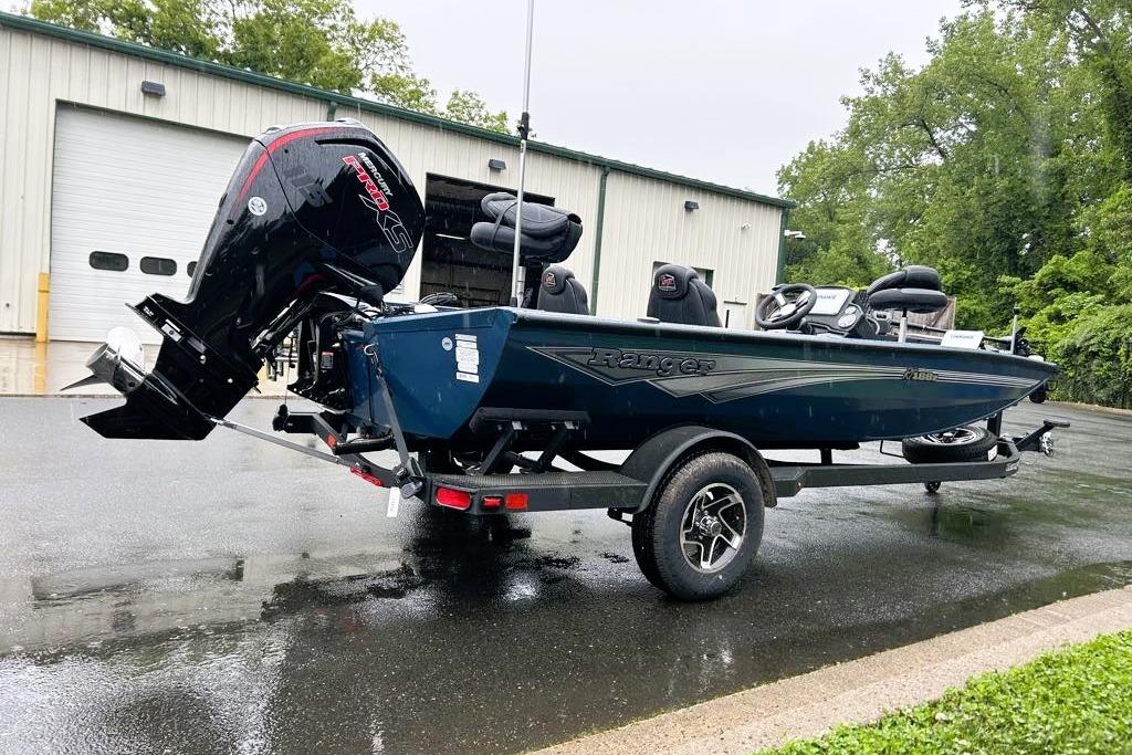 2026 Ranger RT188P boat on trailer, parked outside a garage on a rainy day.