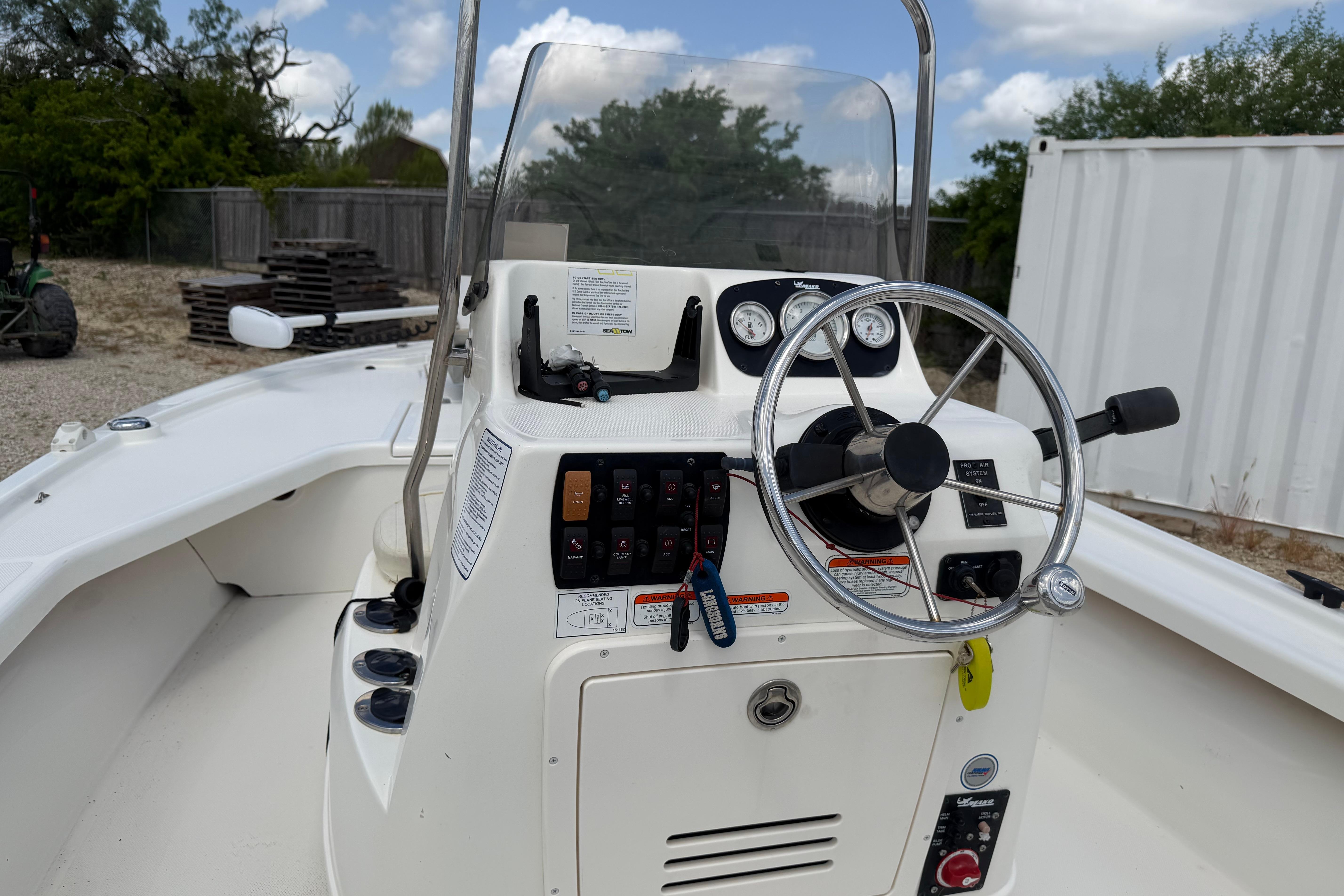 2012 Mako 18 LTS boat console with steering wheel and control panel.