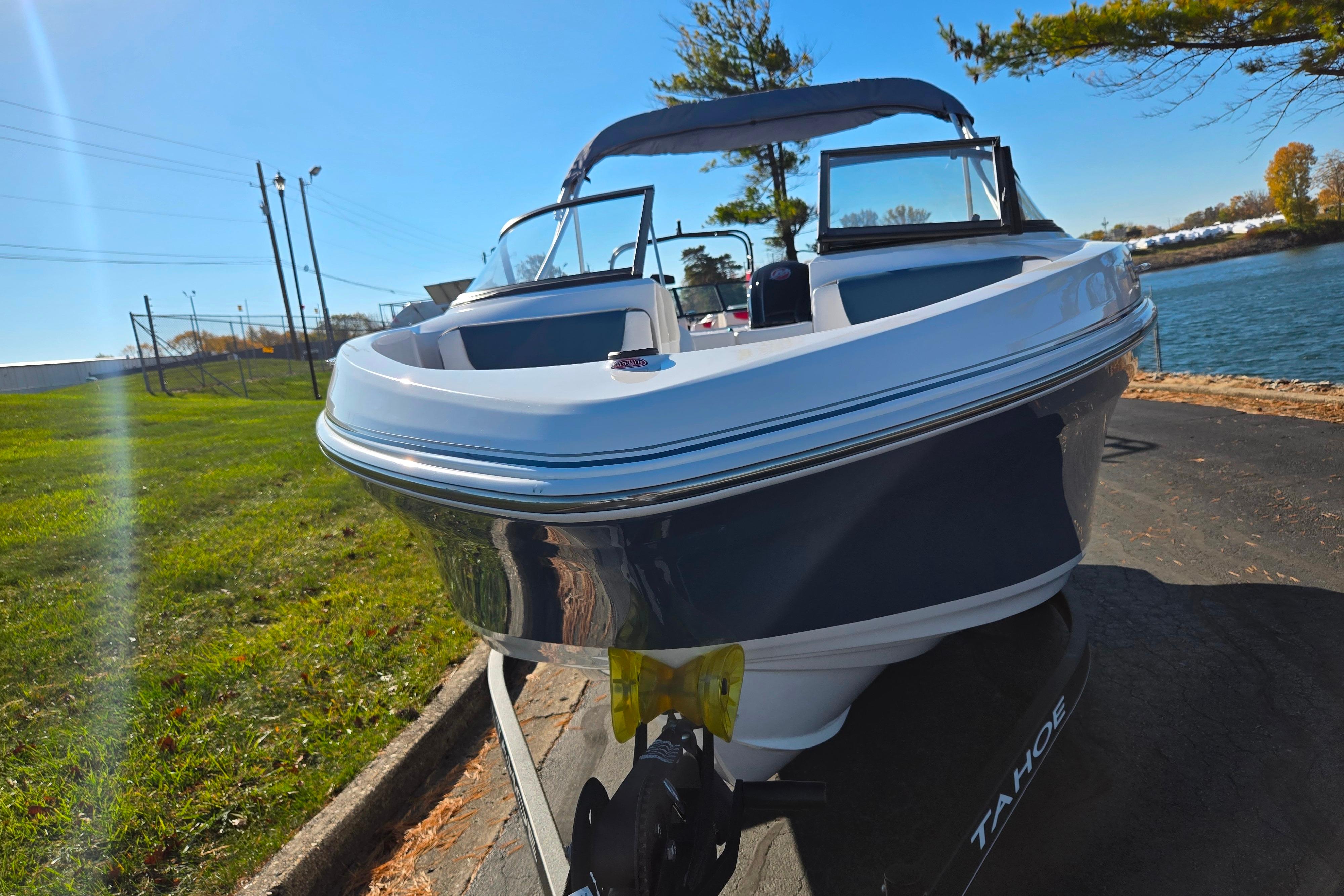 2023 Tahoe 185 S boat on trailer by a lakeside, sunny day.