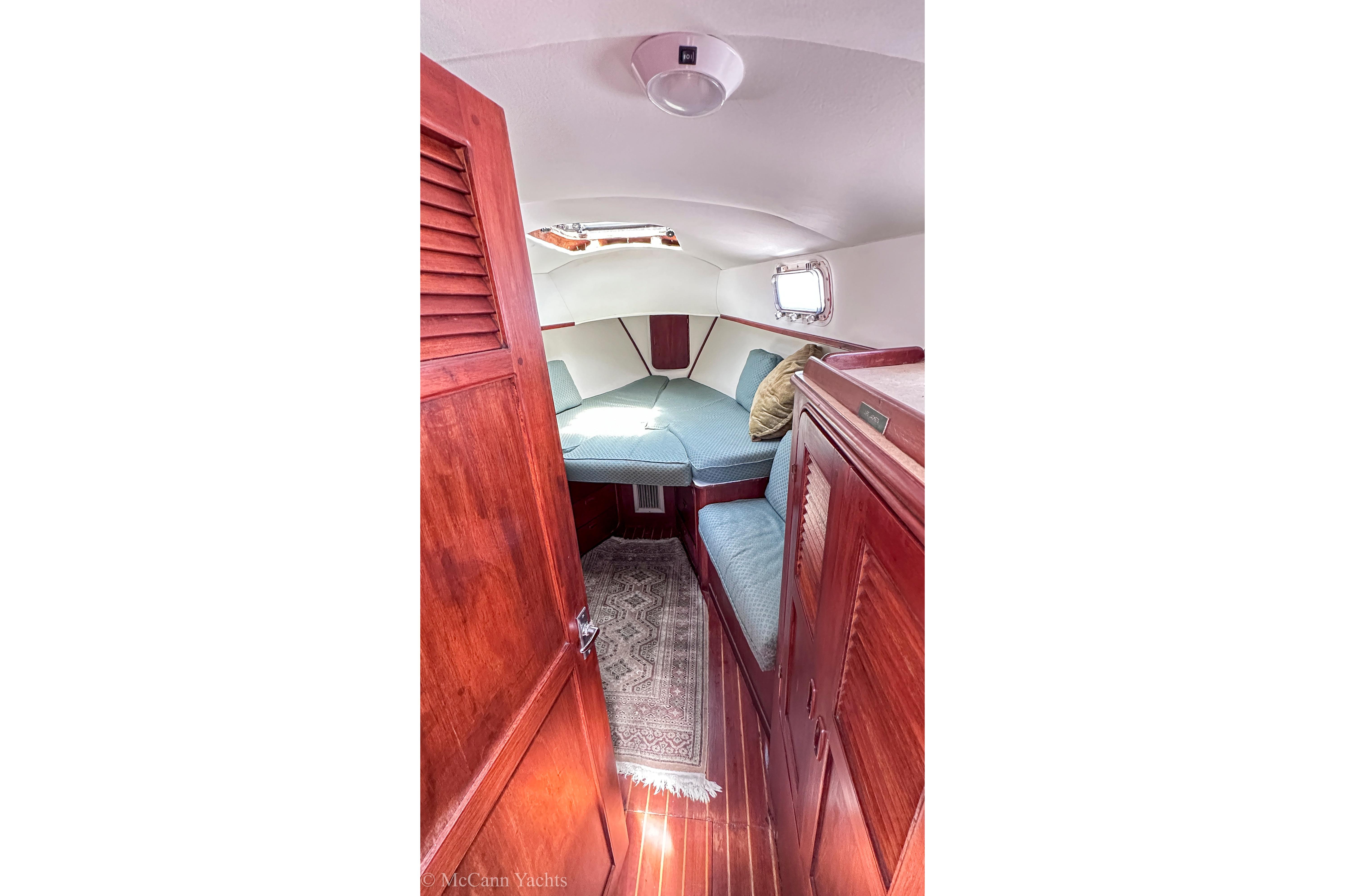 Interior of 1980 Irwin 46 sailboat cabin with wooden finish and cozy seating.