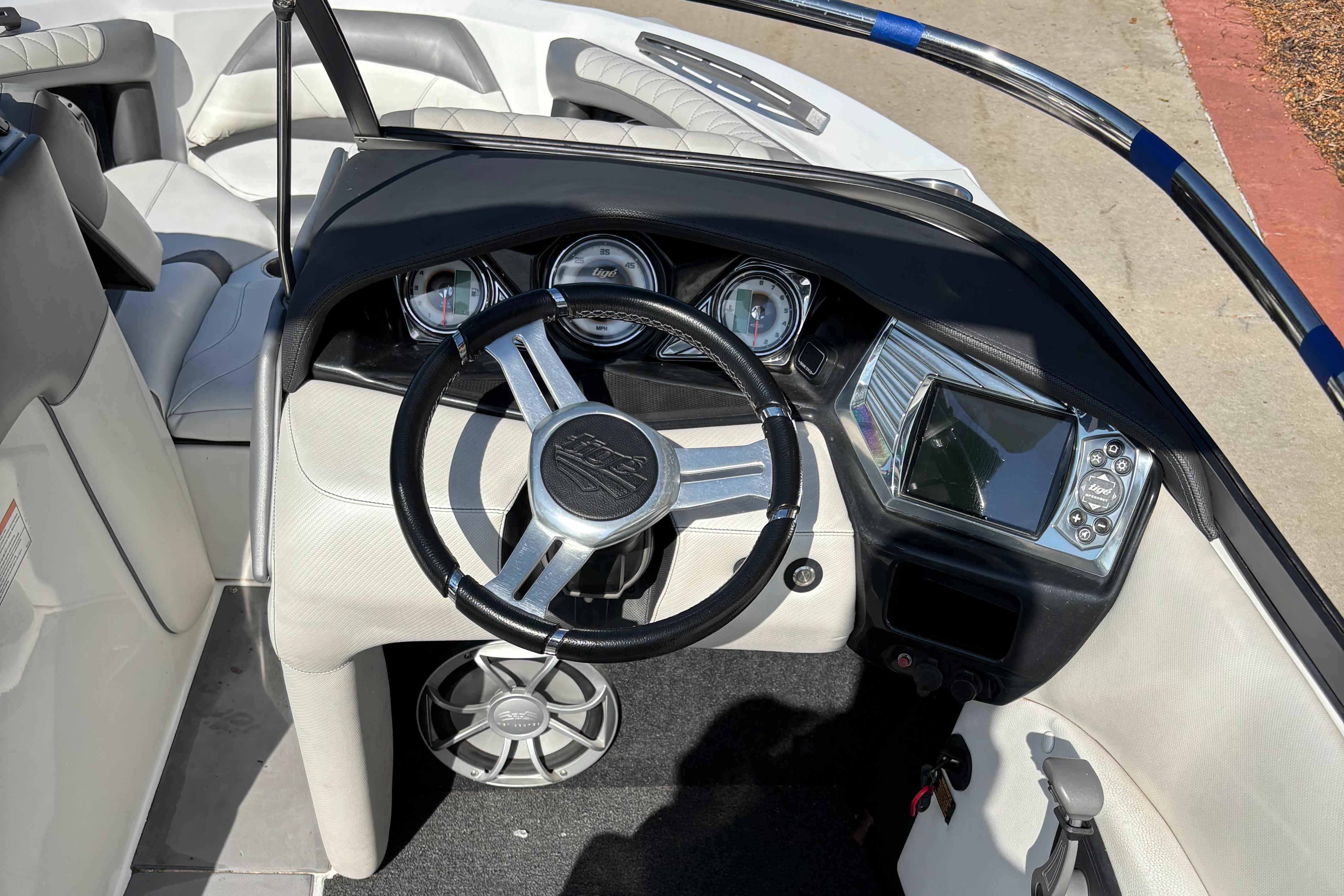 2014 Tigé RZR boat dashboard with steering wheel, gauges, and control panel.