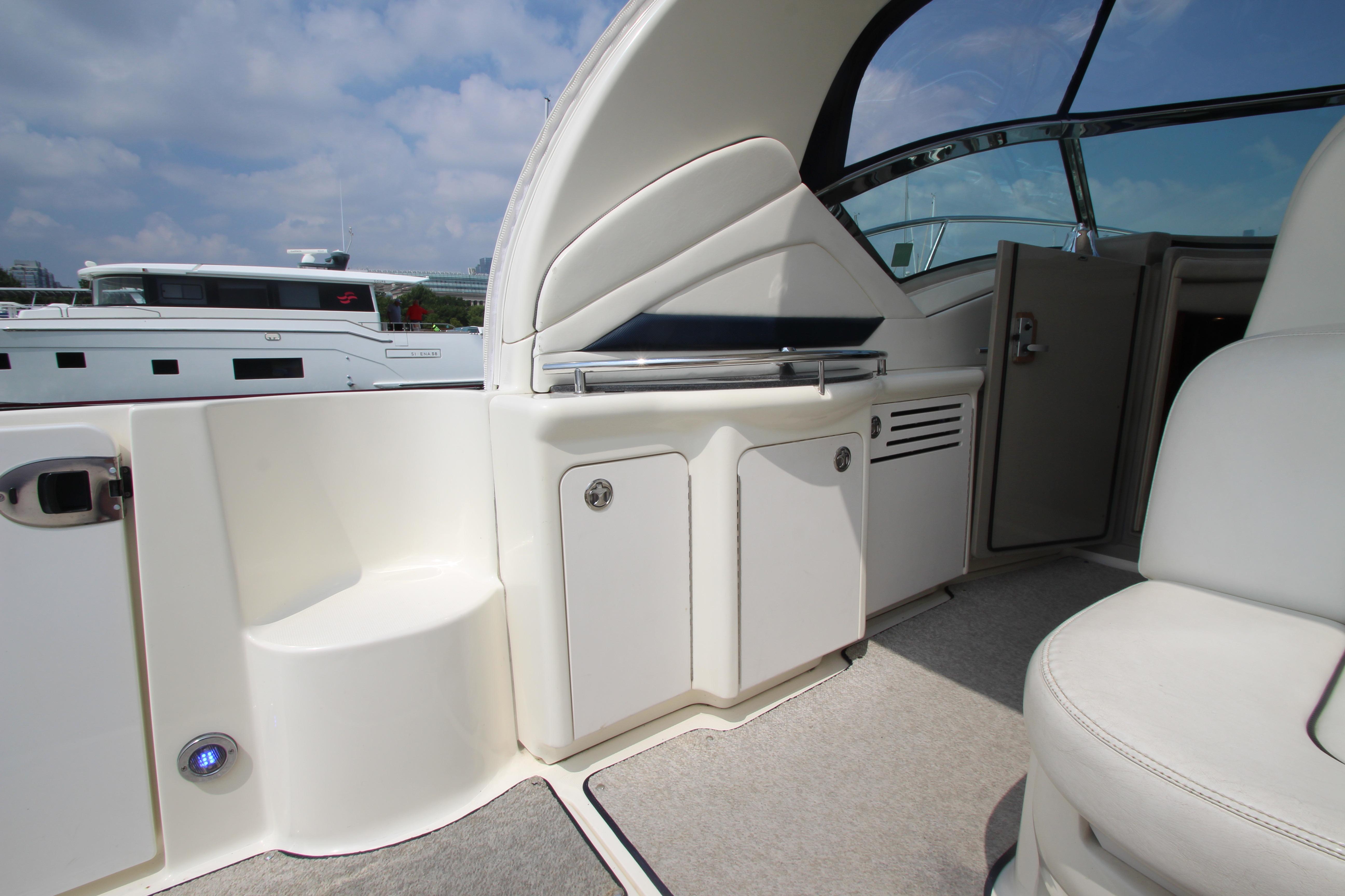 2004 Sea Ray 40 Sundancer yacht interior with seating and storage, under a clear sky.