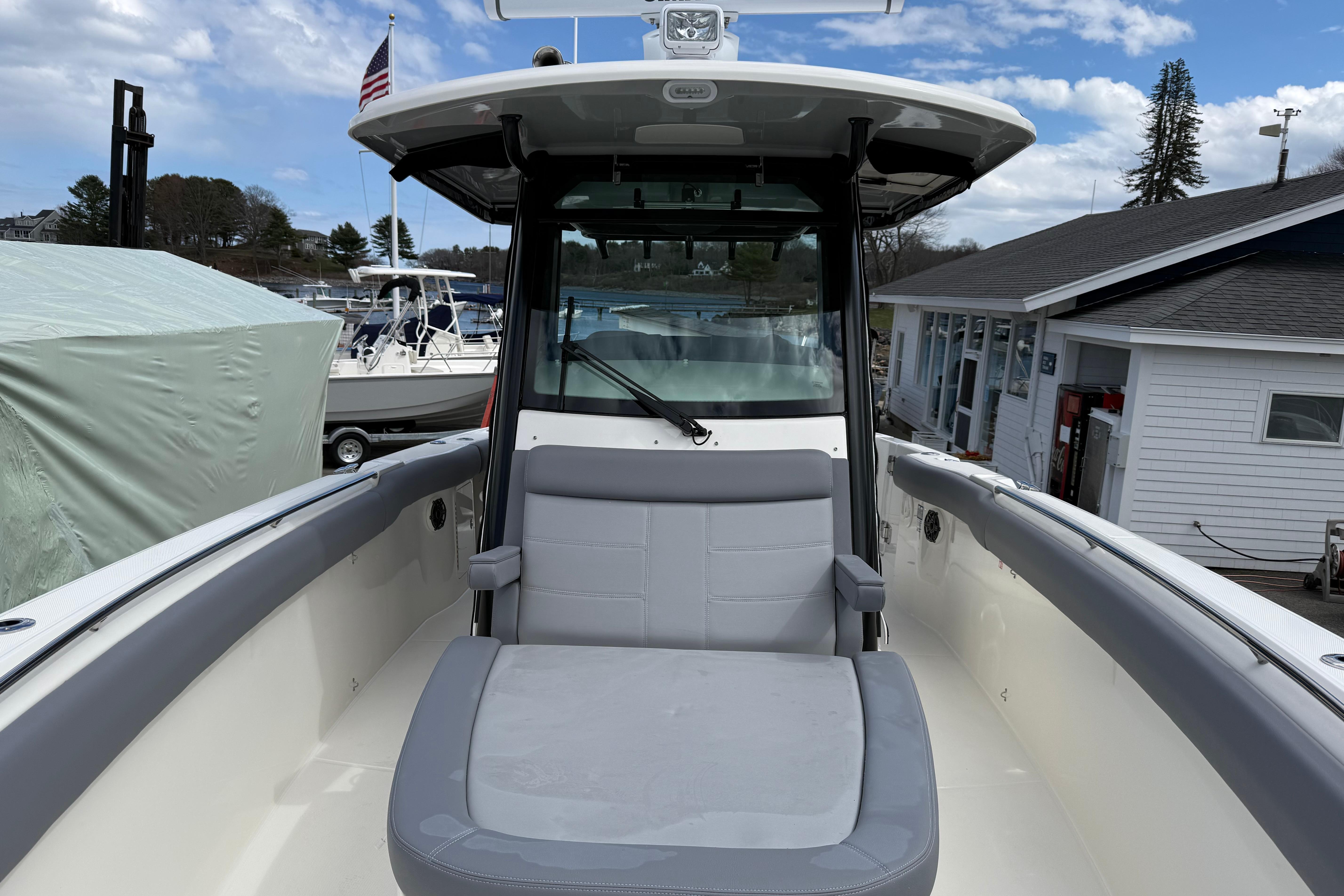 2026 Boston Whaler 330 Outrage boat with seating, docked at marina under blue sky.