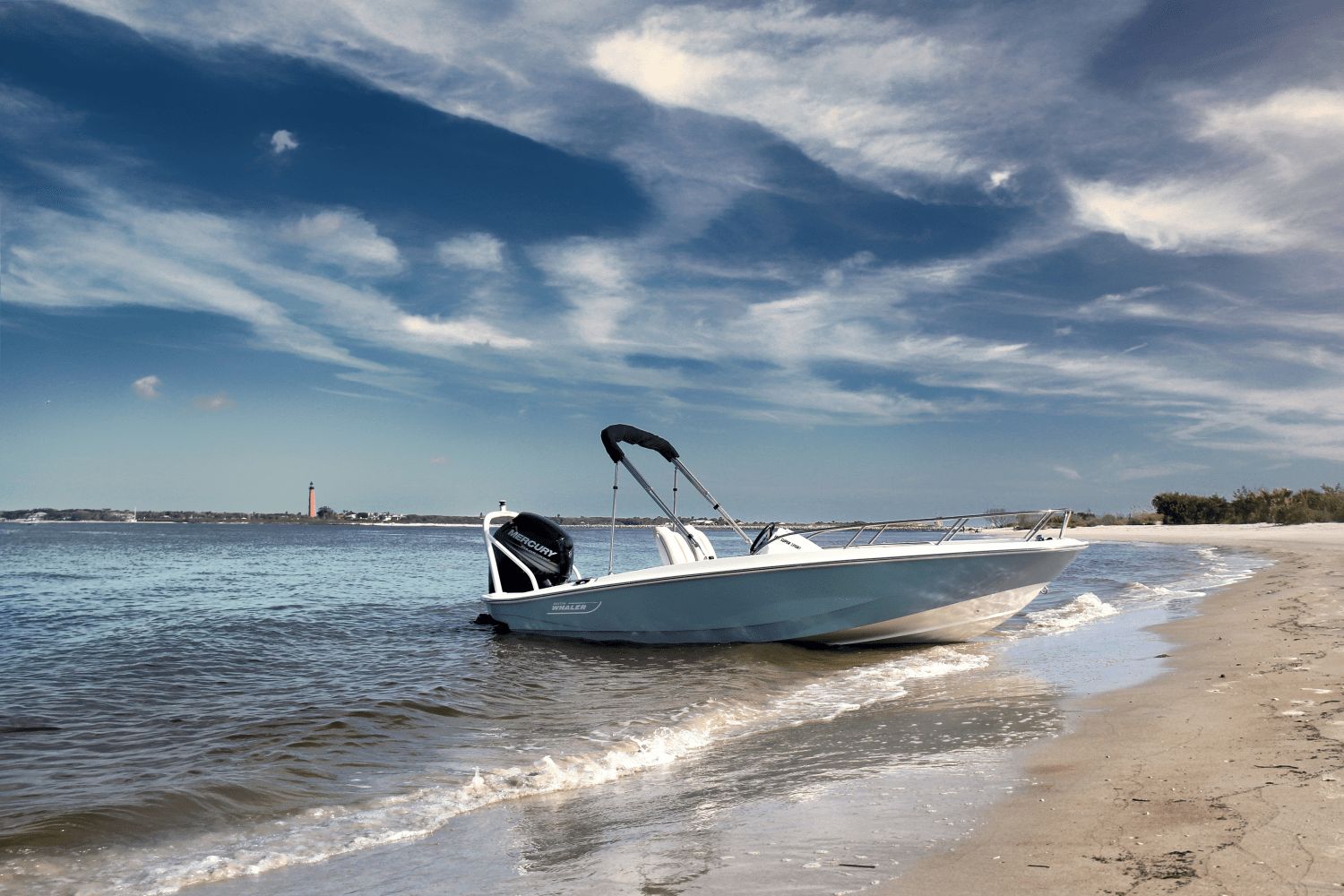 Boston Whaler 160 Super Sport on a beach with a lighthouse in the background.