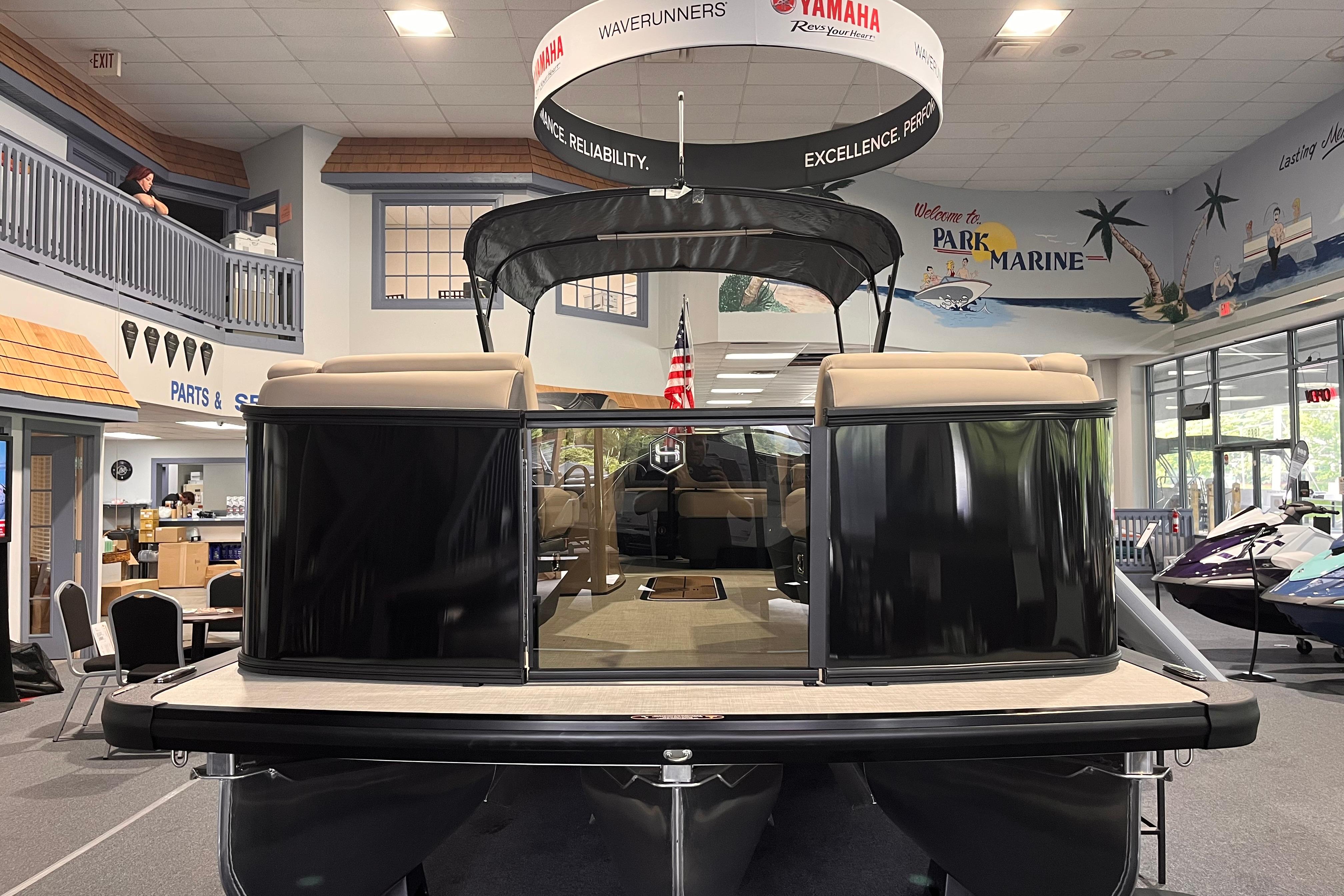 2026 Harris Sunliner 250 pontoon boat displayed indoors at a marine showroom.