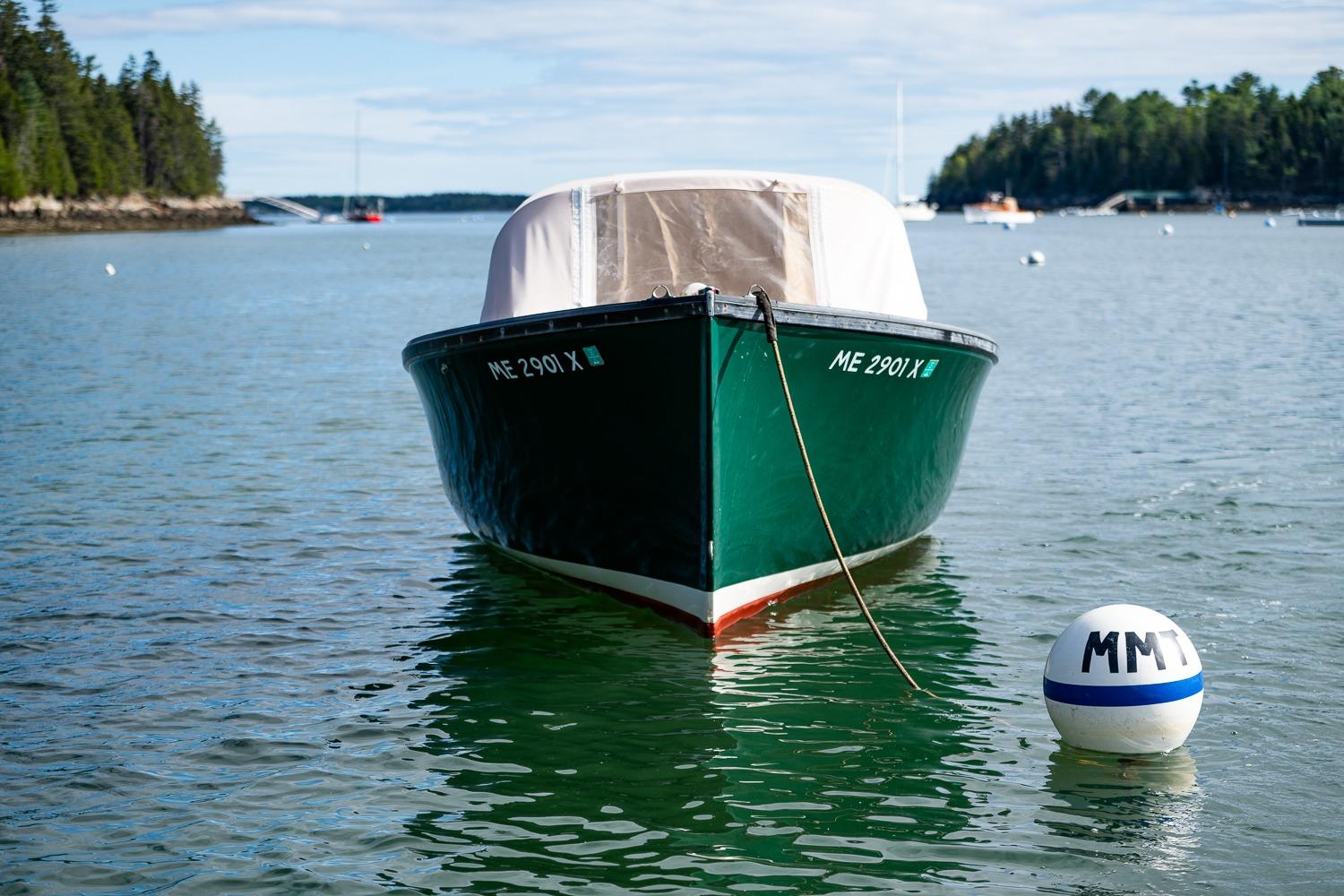 1989 Ellis 24 Open boat moored in scenic harbor with buoy, surrounded by calm waters.