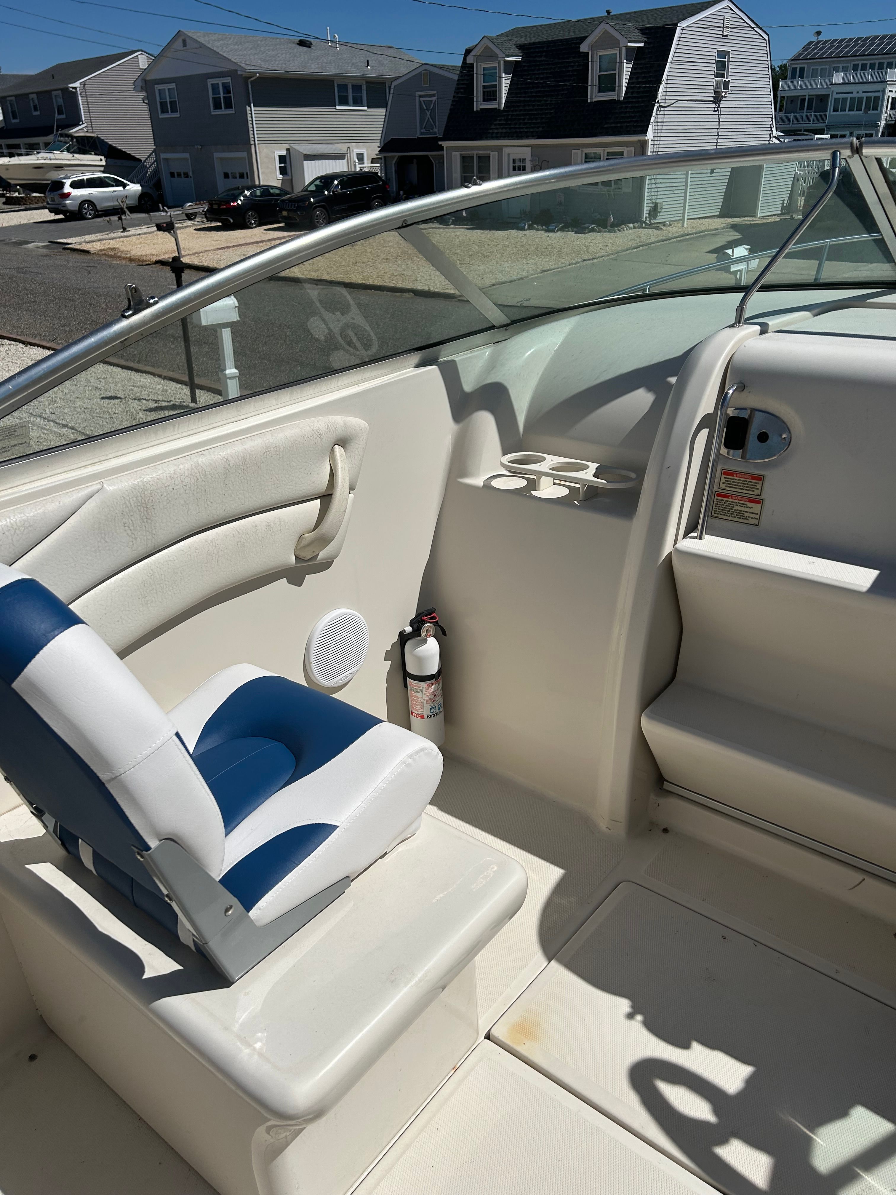The image shows the cockpit of a 2002 Sea Ray 225 Weekender with a blue and white seat.