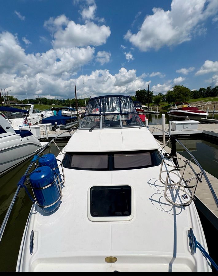 A 2014 Regal 30 Express boat docked at a marina, surrounded by other boats.