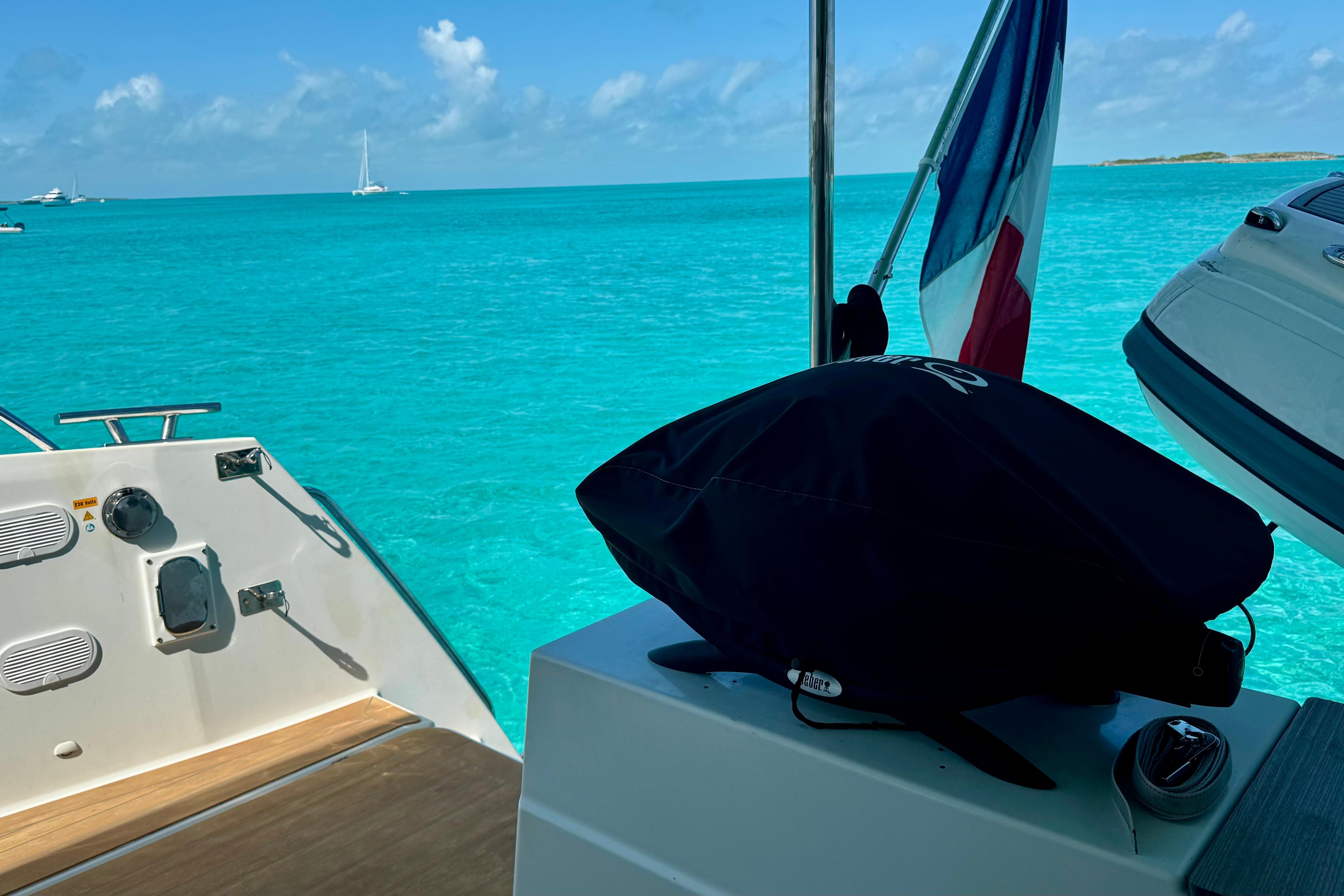 Fountaine Pajot Saona 47 yacht on turquoise waters, featuring a flag and clear sky.