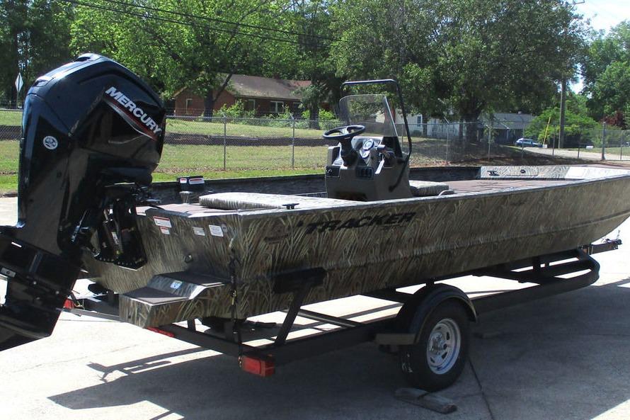2026 Tracker Grizzly 2072 CC boat on trailer with Mercury engine, parked outdoors.