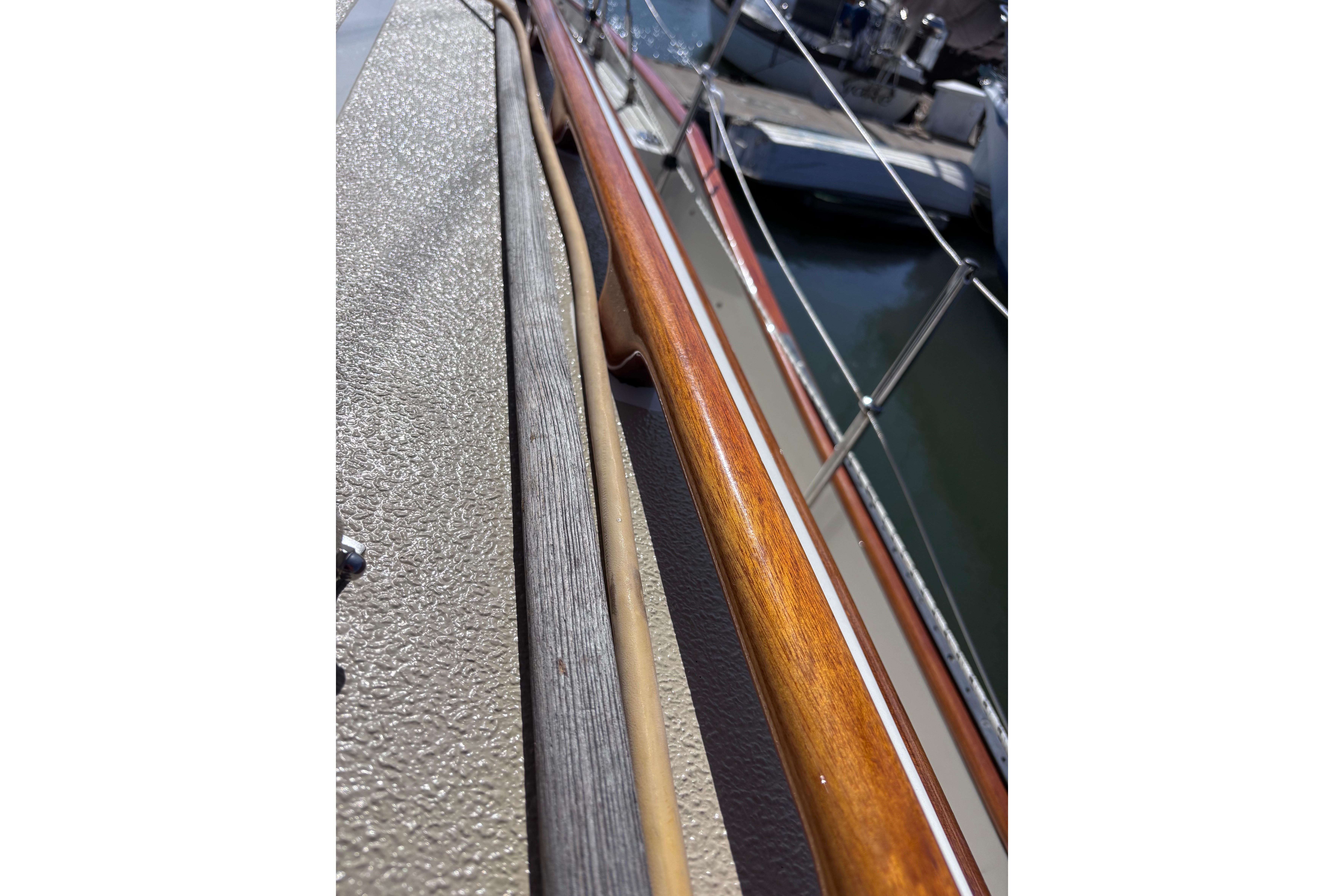 Close-up of a 1978 Swift 33 boat railing with wood and metal details.