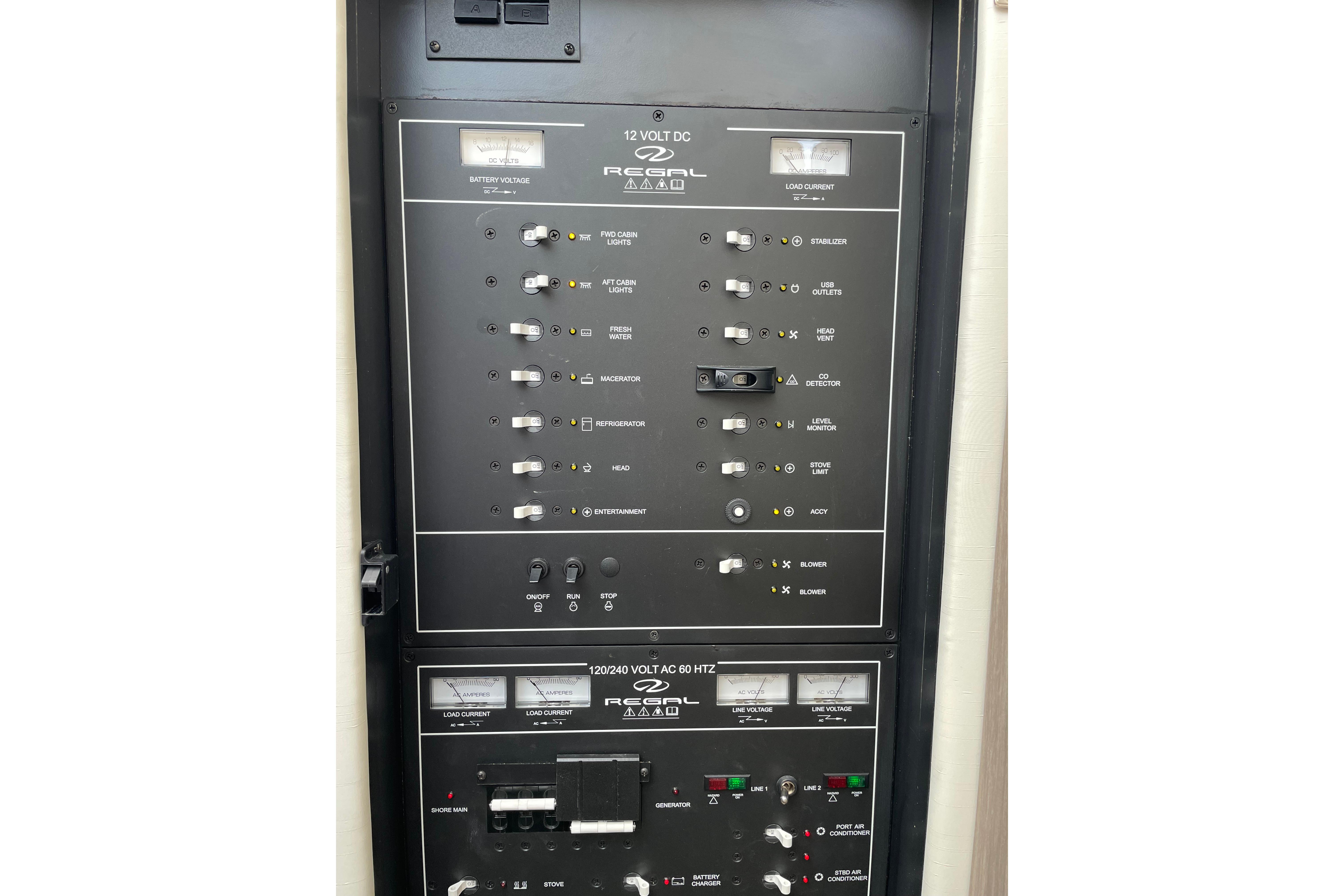 Electrical control panel of 2022 Regal 38 Grande Coupe yacht, featuring various switches and indicators.