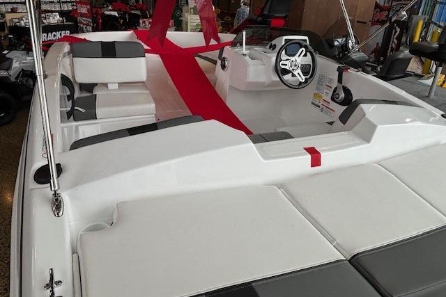 2026 Tahoe T16 boat interior with steering wheel and seating, displayed in showroom.
