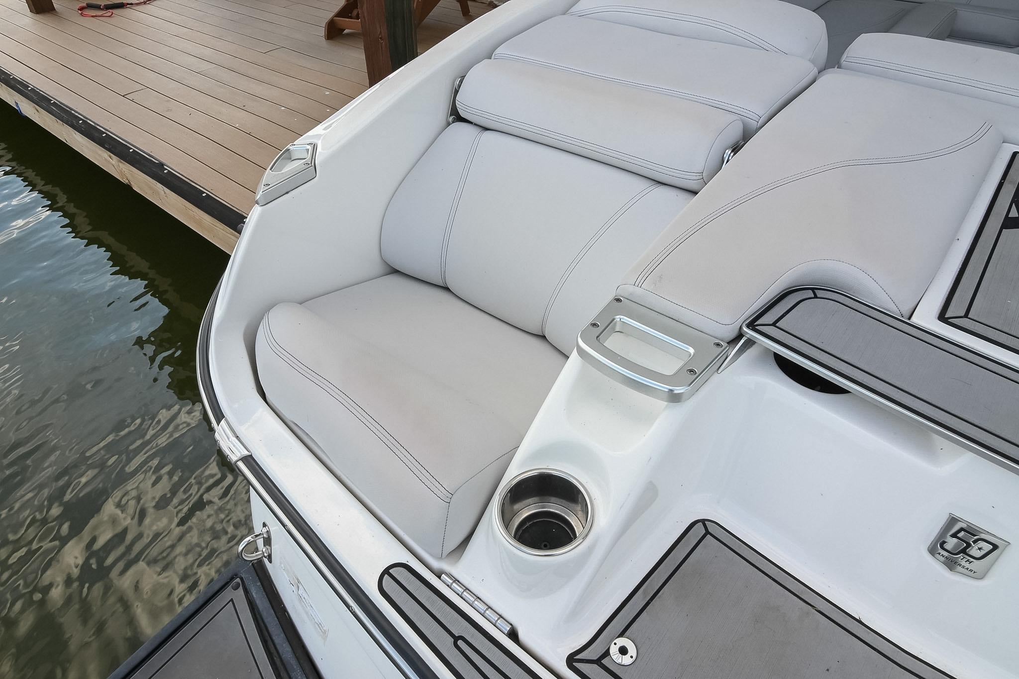 2018 MasterCraft X23 boat interior with white cushioned seating and cup holder.
