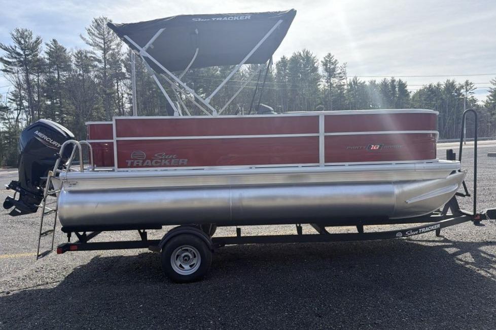 2026 Sun Tracker Party Barge 18 DLX pontoon boat on trailer, parked outdoors.