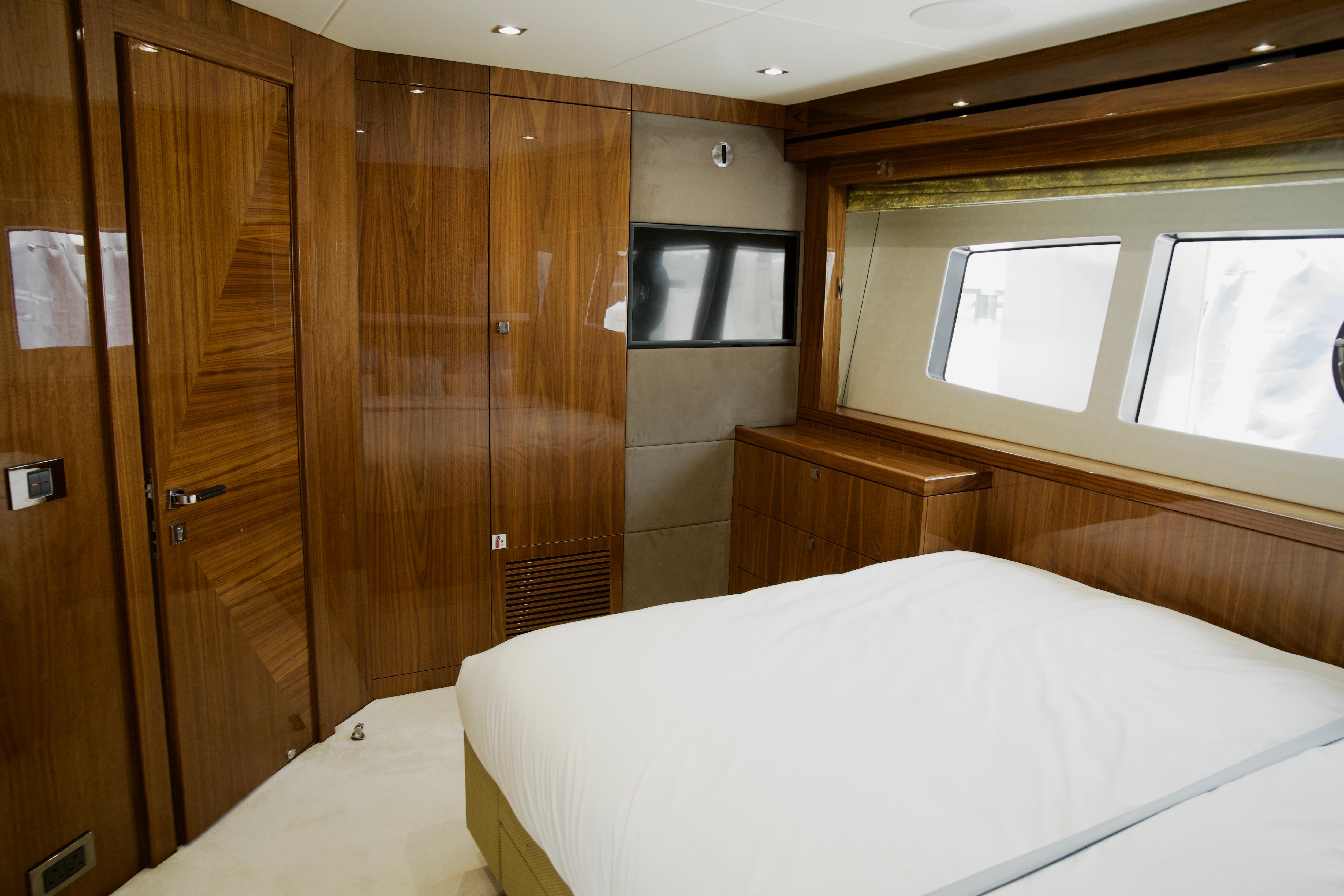 Luxurious Sunseeker 95 Yacht 2018 bedroom with elegant wood paneling and large windows.