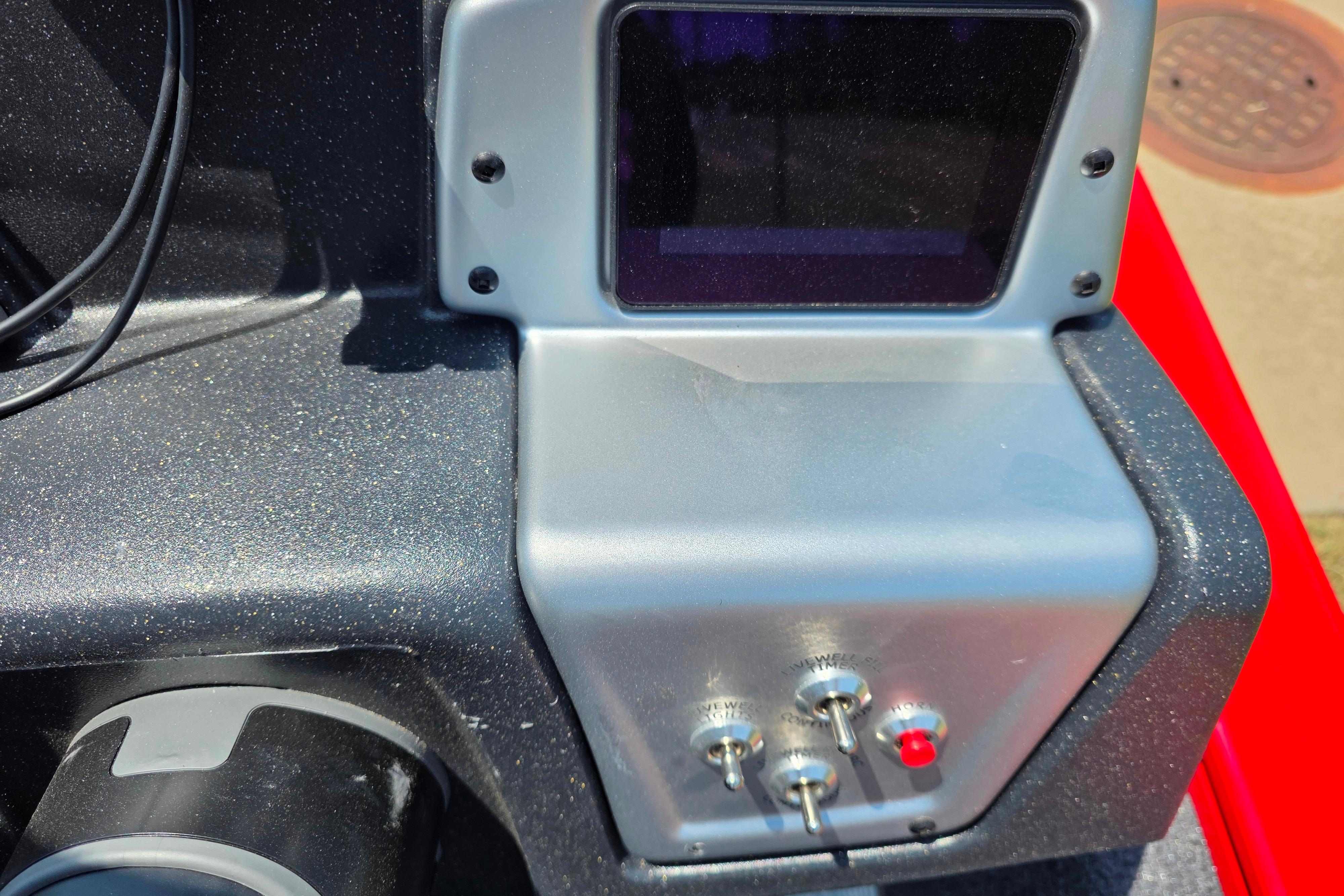 Control panel of 2026 Tracker Pro Team 195 boat with switches and display screen.