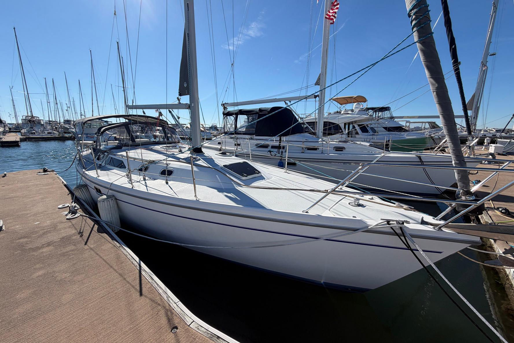 2001 Catalina 36 MkII sailboat docked at a marina under clear blue skies.