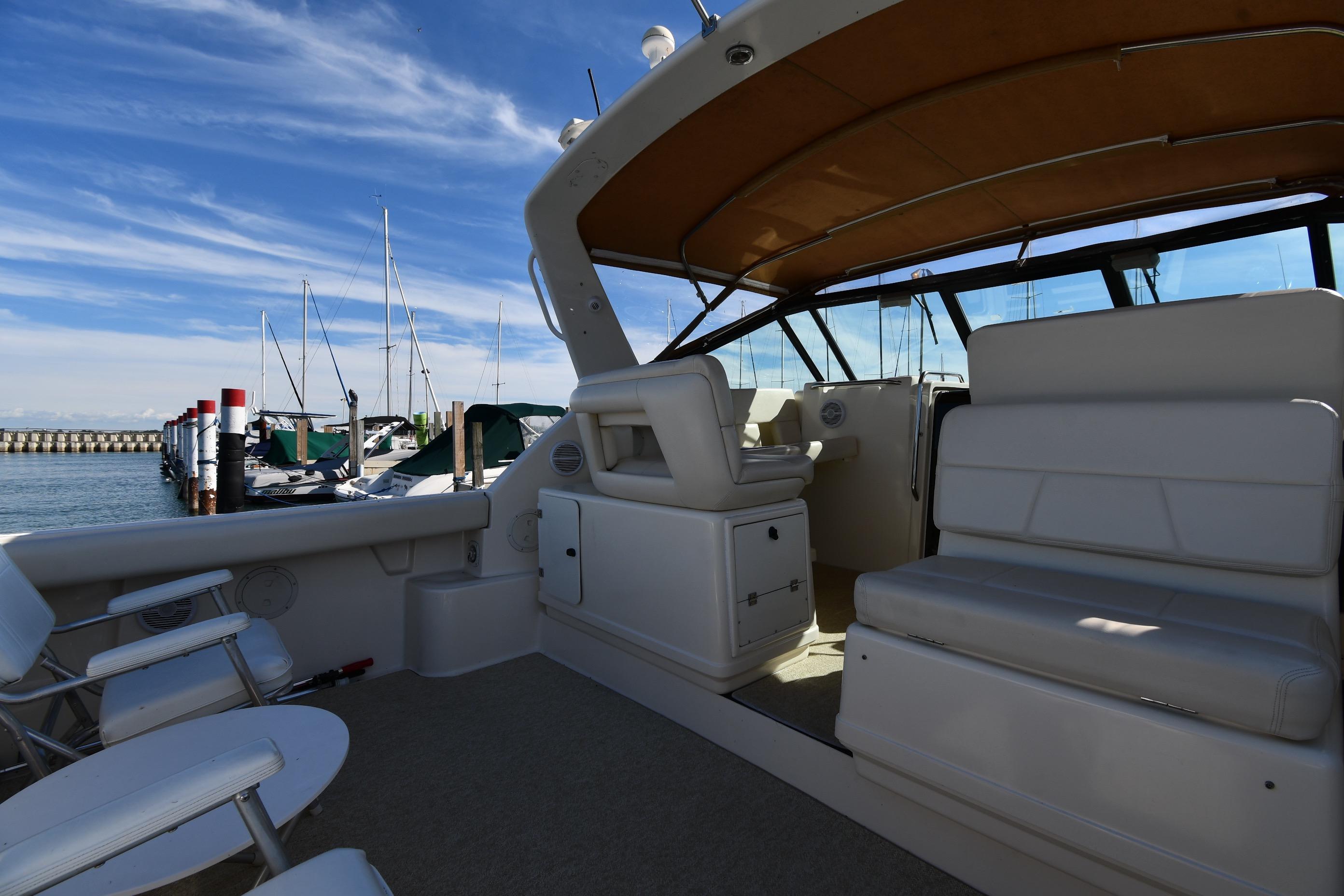 1998 Tiara Yachts 3100 Open interior with seating, docked at marina under blue sky.