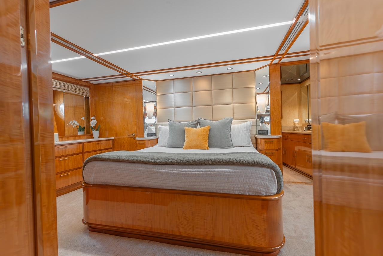 Luxurious bedroom interior on 2001 Intermarine RPH 95 yacht with elegant wood finishes.