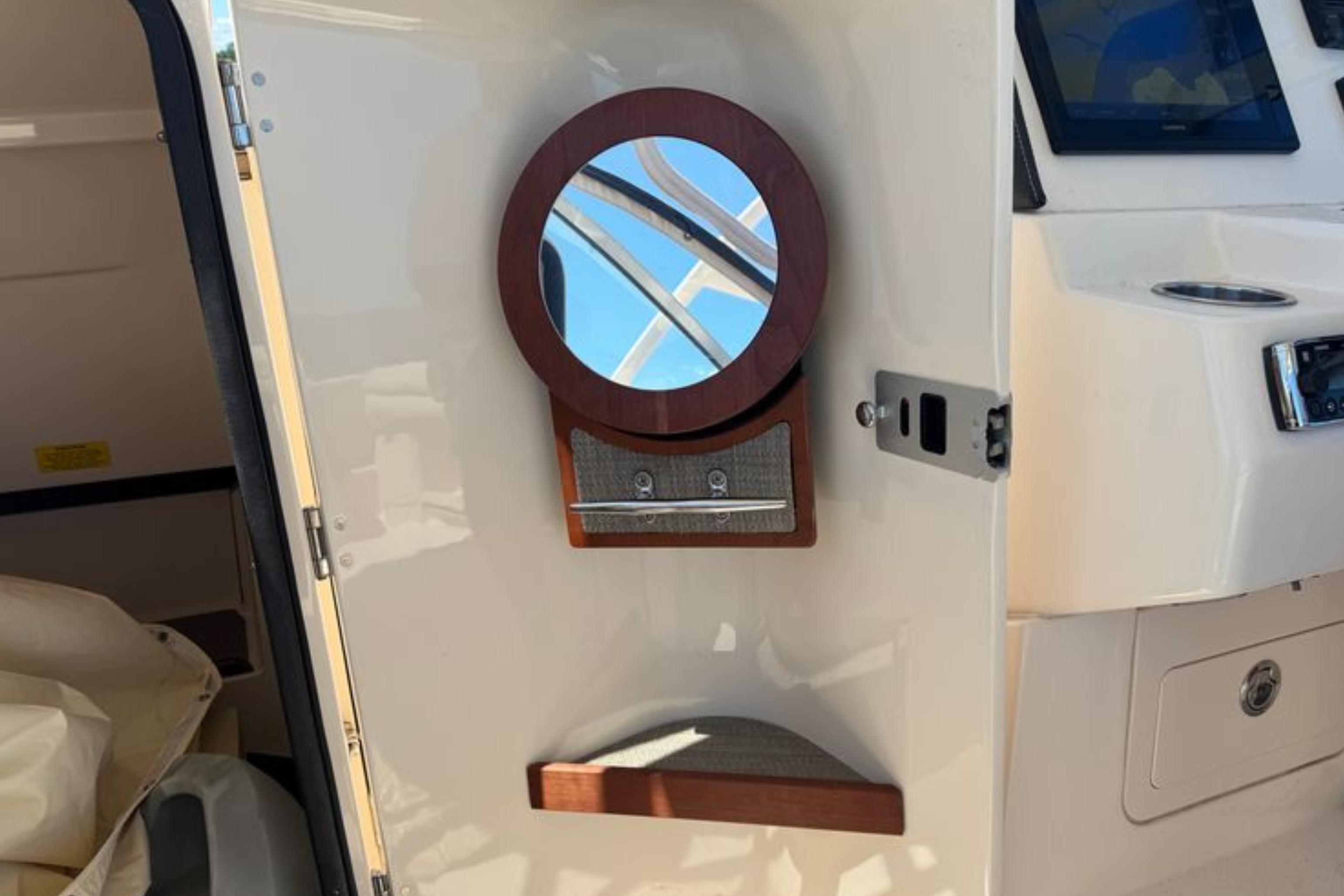Interior of 2017 Grady-White Freedom 235 boat with circular mirror and storage.