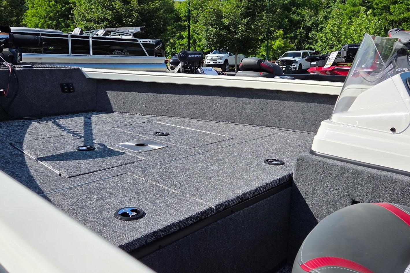 2026 Ranger VS1665SC boat interior with carpeted deck and seating, surrounded by greenery.