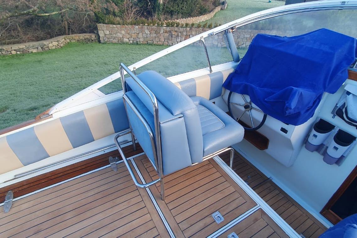 Interior of 1989 Fairey Spearfish MKIII boat with blue seating and wooden deck.
