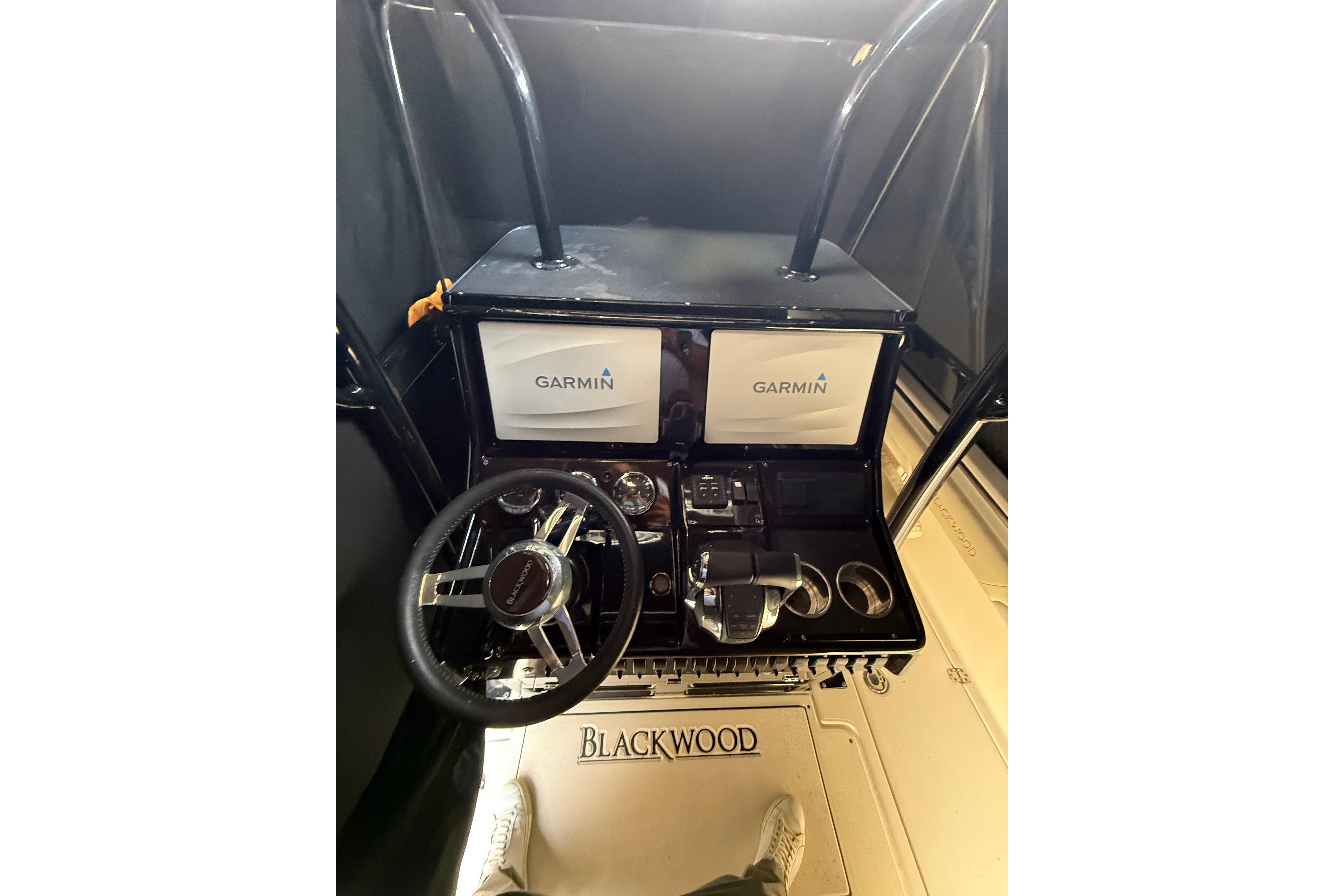 Cockpit of 2015 Blackwood 27 boat with Garmin navigation system and steering wheel.