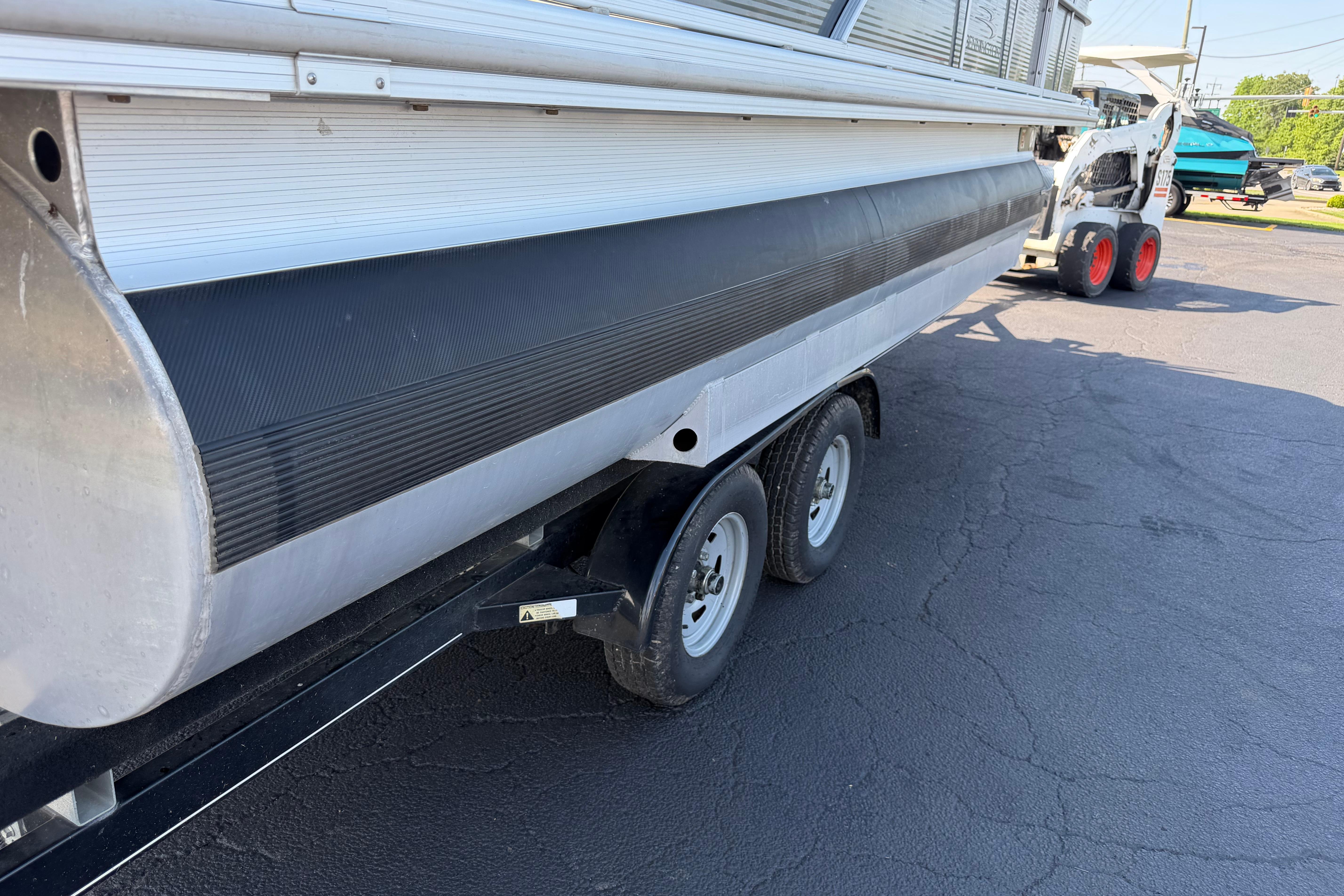 2018 Bennington 21 SF pontoon boat on a trailer, parked on asphalt.