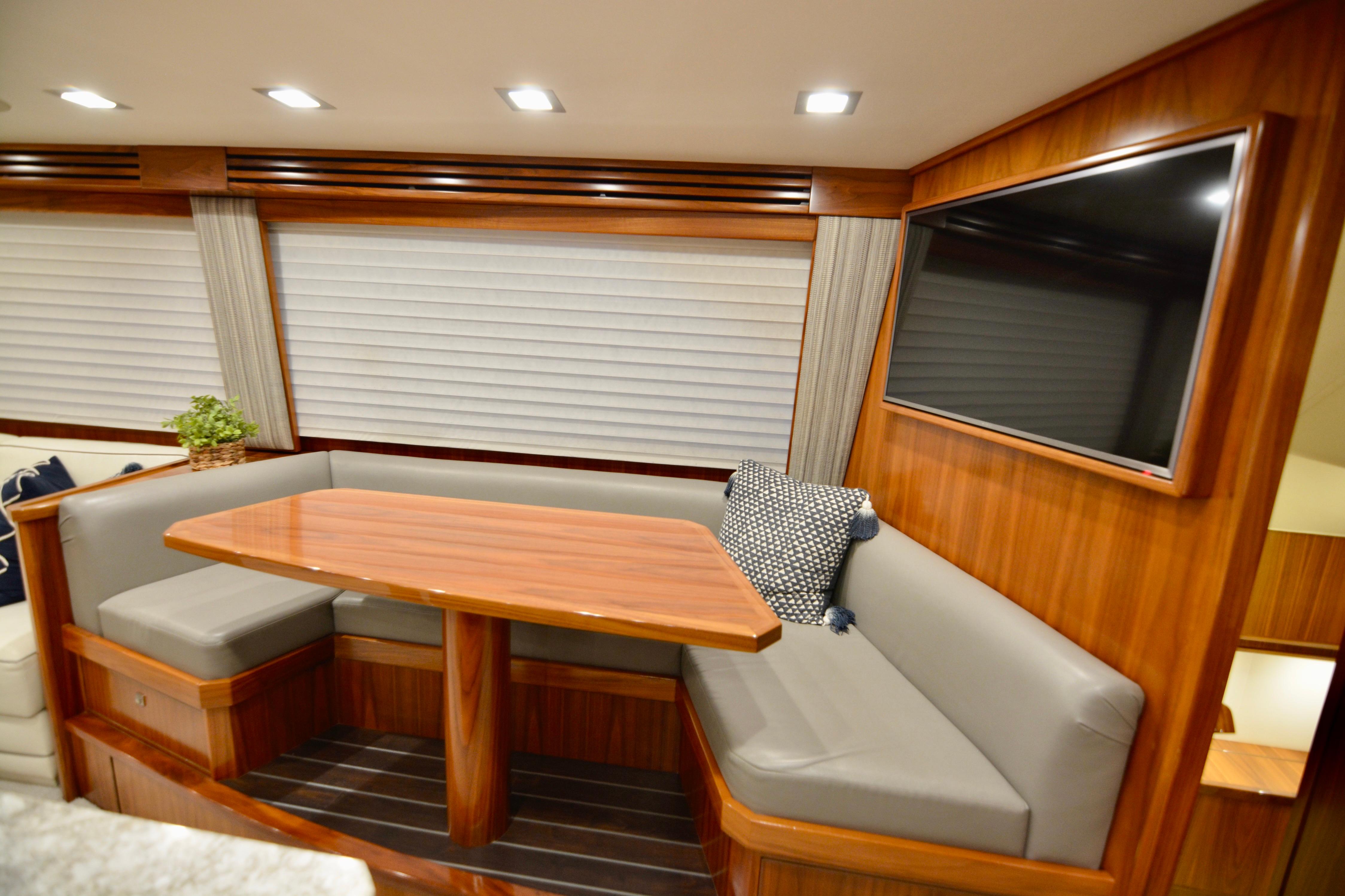 Luxurious interior of 2019 Viking 68 Convertible yacht with wood finish and seating area.