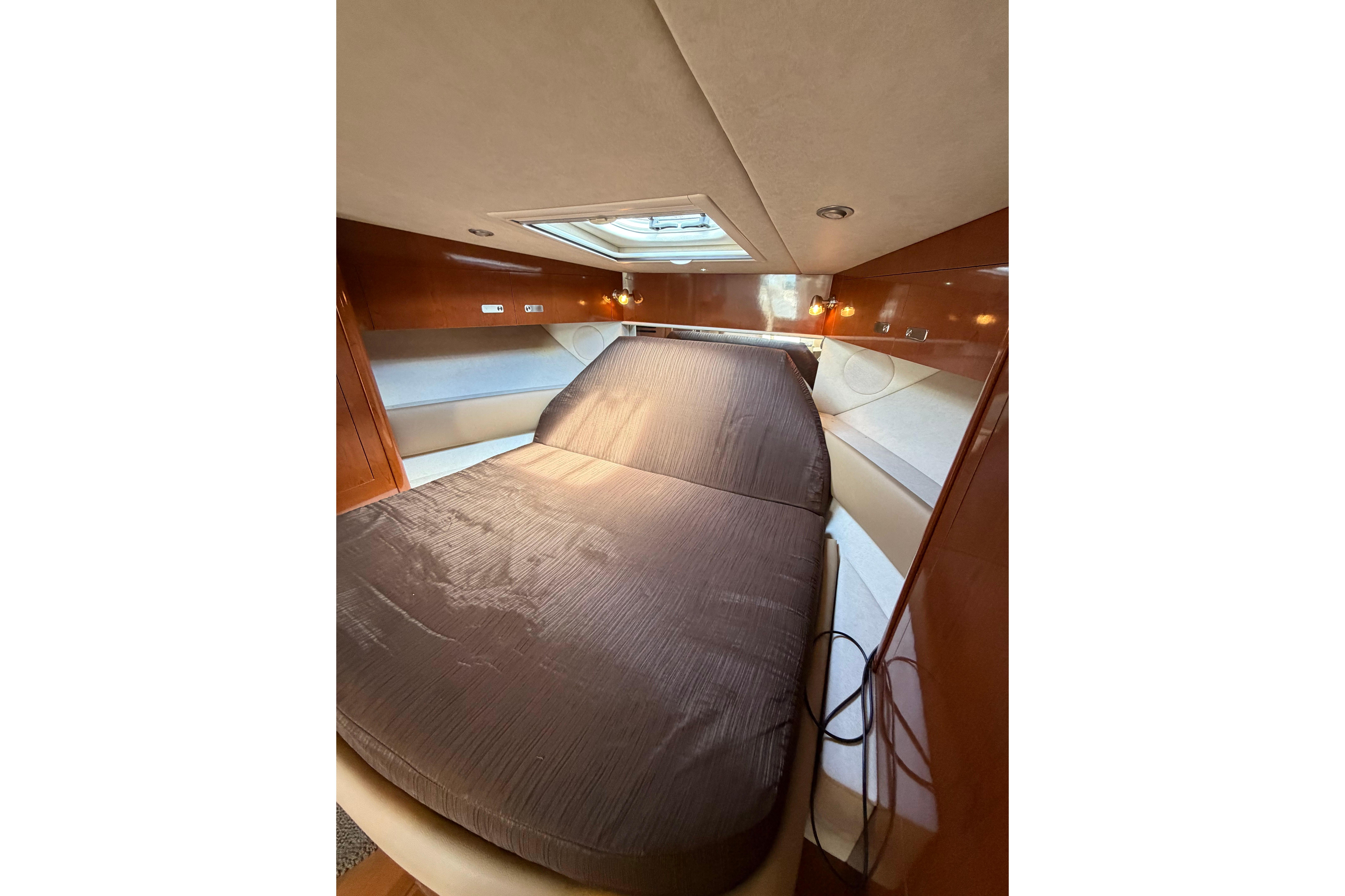 Luxurious cabin interior of 2012 Sea Ray Sundancer 370 yacht with cozy bedding.