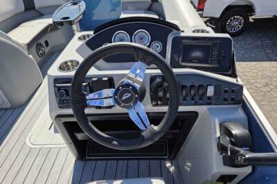 2026 SunCatcher Select 322RC boat dashboard with steering wheel and control panel.