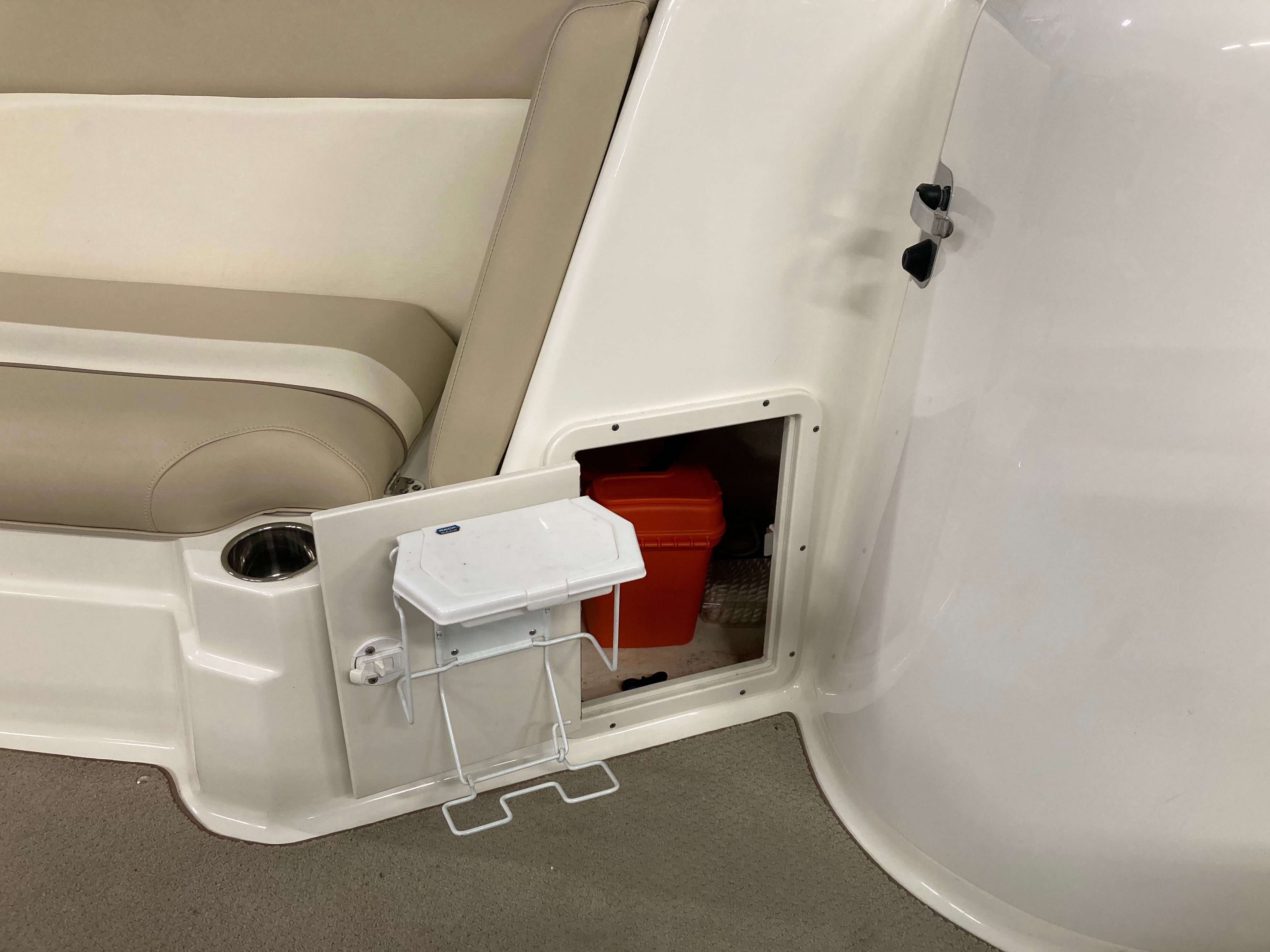 Boat interior with storage compartment and seating area.