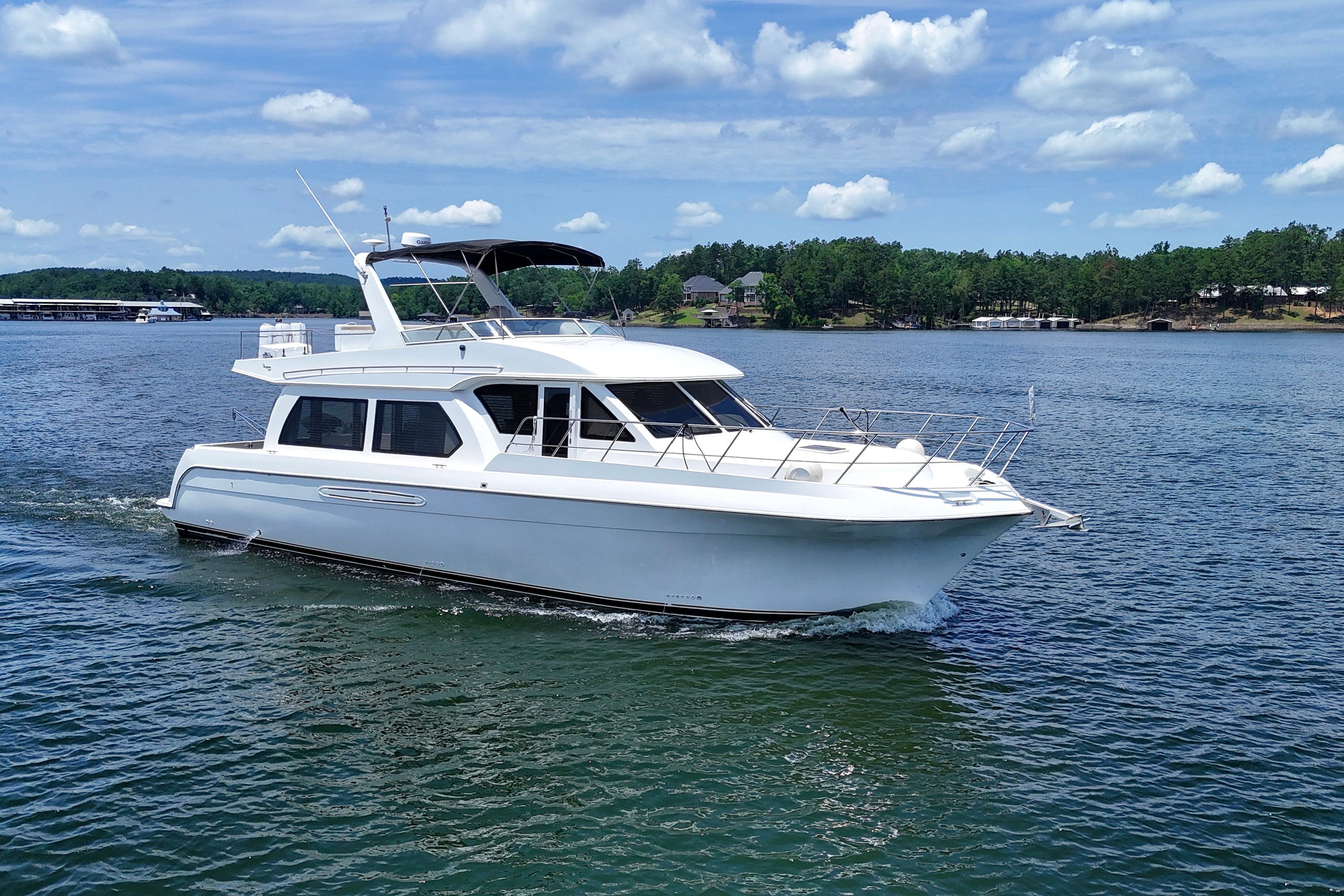 2007 Navigator 5100 yacht cruising on a serene lake under a clear blue sky.