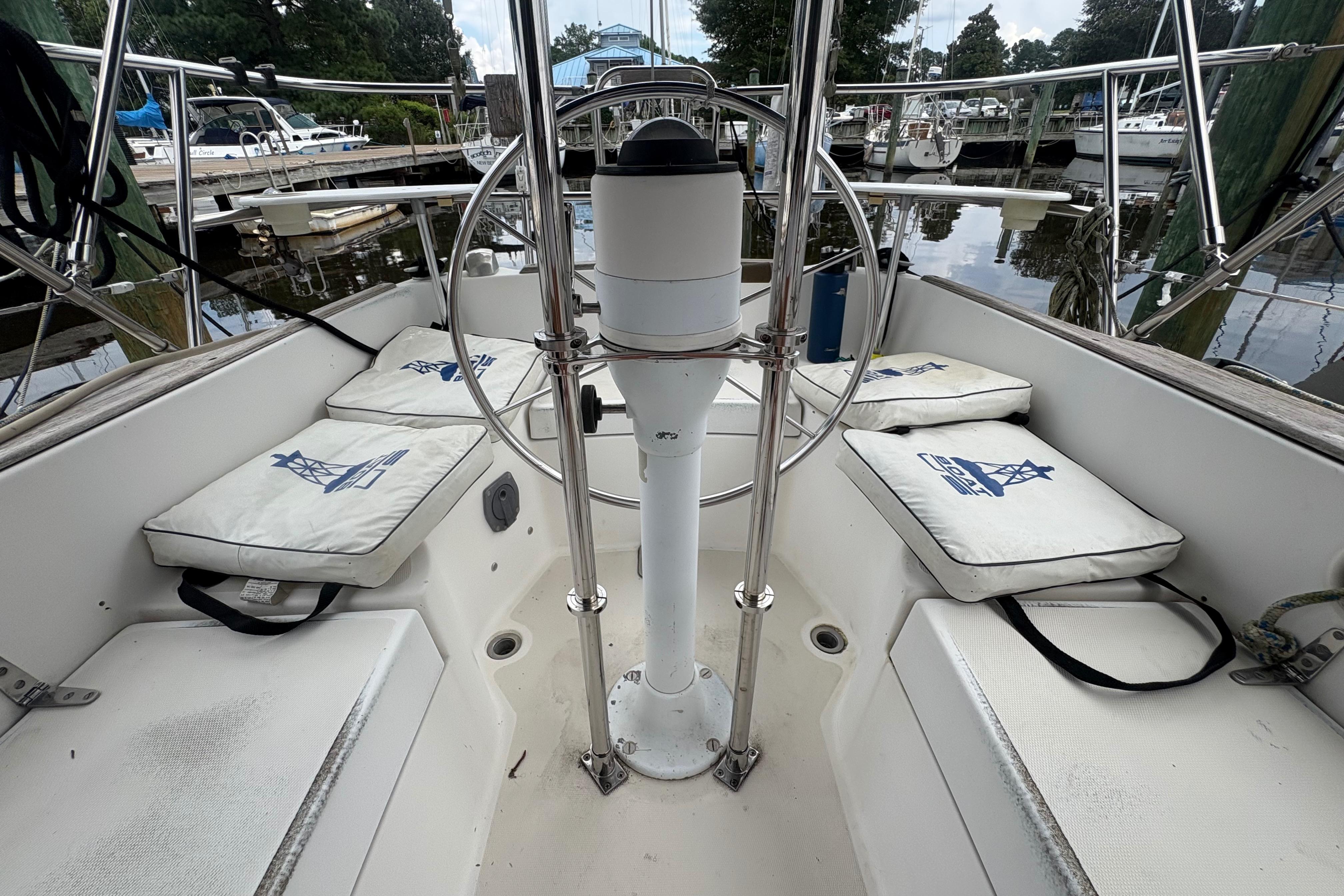 Cockpit of 1981 Sabre 31 sailboat with cushioned seating and steering wheel.