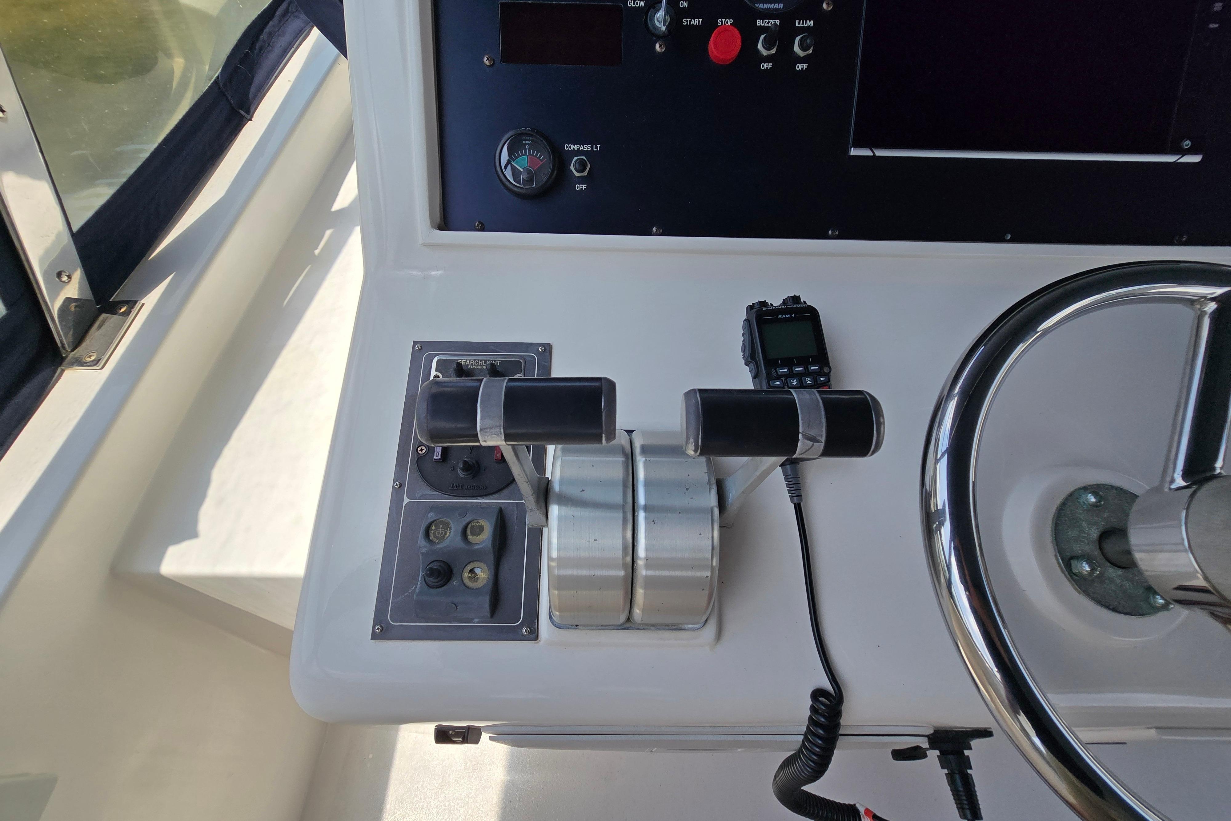 Control panel of a 2004 Grand Harbour 58 yacht, featuring throttle levers and steering wheel.
