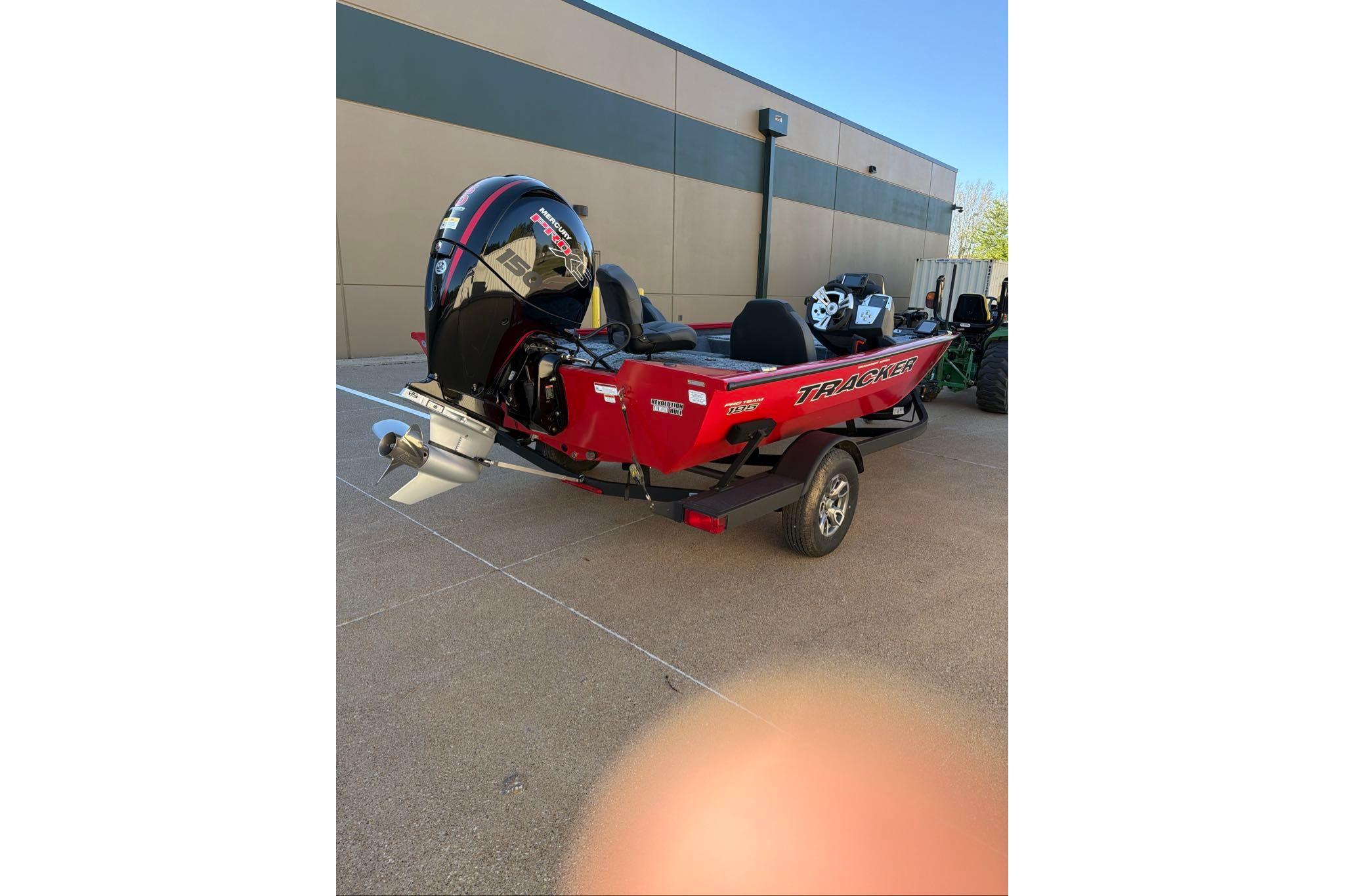 2026 Tracker Pro Team 195 boat with powerful outboard motor, parked outdoors.