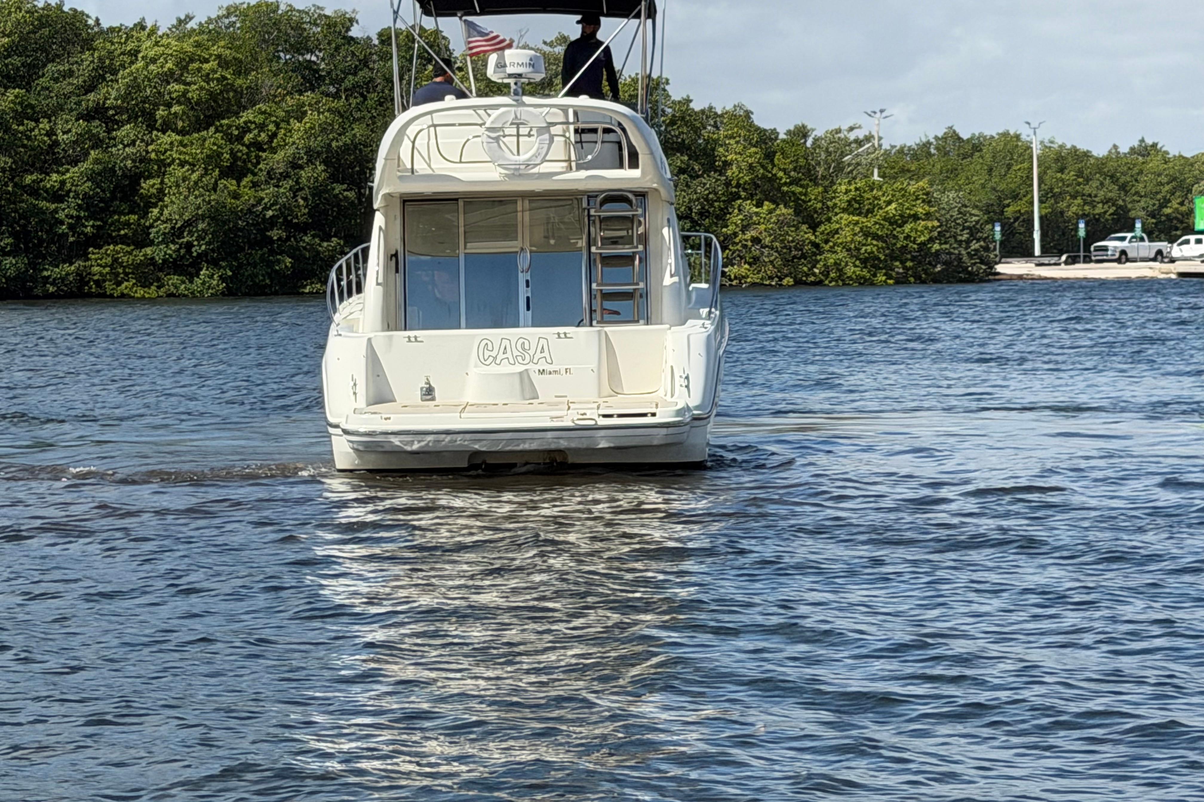 2007 Cranchi Atlantique 40 yacht cruising on a calm river with lush greenery.