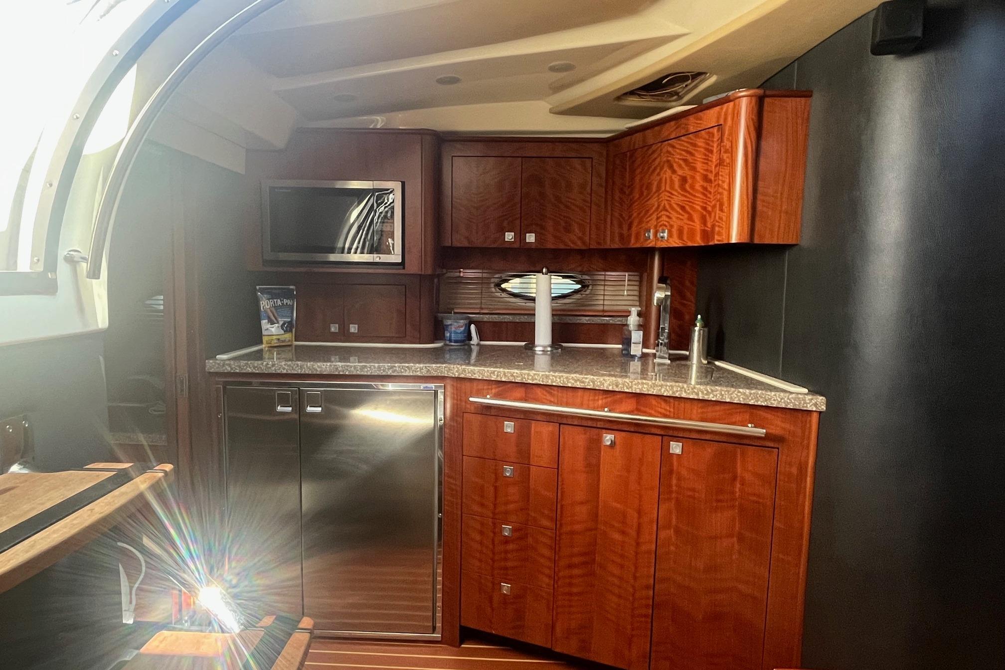 Luxurious kitchen interior of 2010 Monterey 400 Sport Yacht with wood cabinetry and modern appliances.