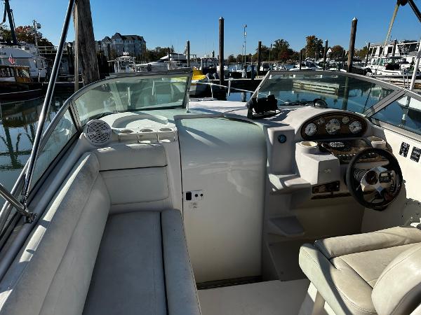 2004 Rinker Fiesta Vee 250 boat interior at marina, featuring steering console and seating.