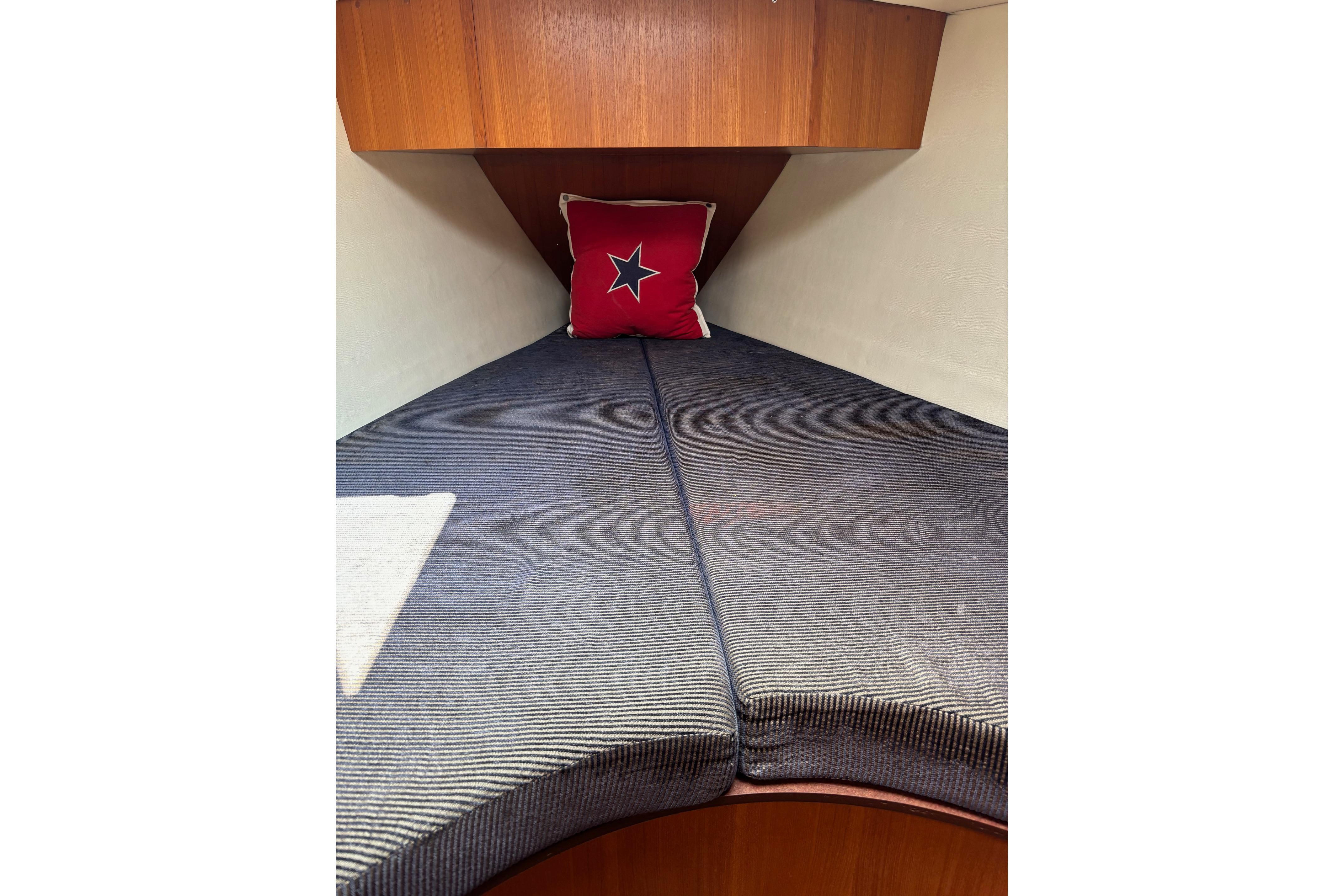 Cozy cabin interior of 2004 Hunter 386 sailboat with star-themed pillow.