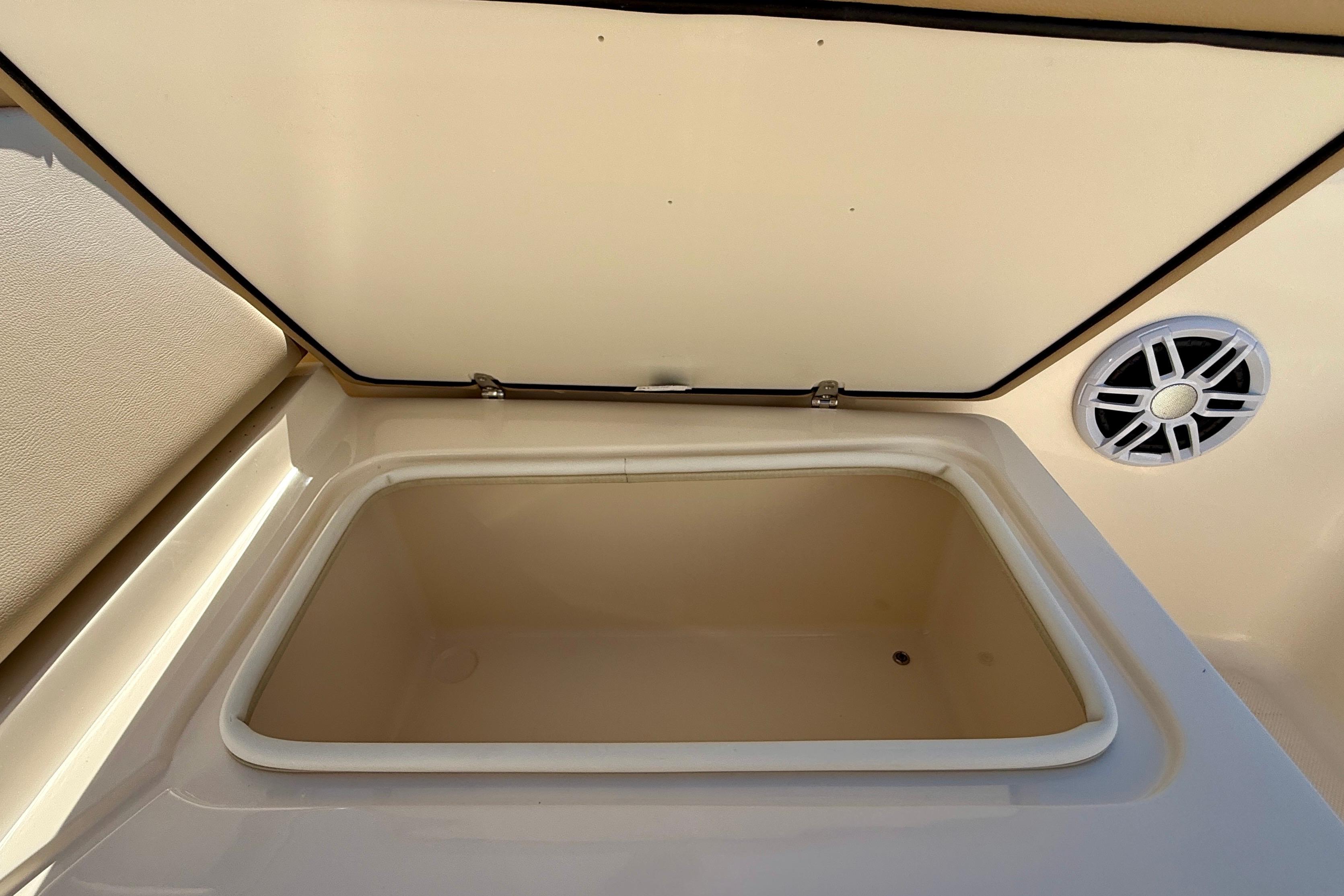 Open storage compartment on 2026 Scout 175 Sport Dorado boat, featuring a speaker.
