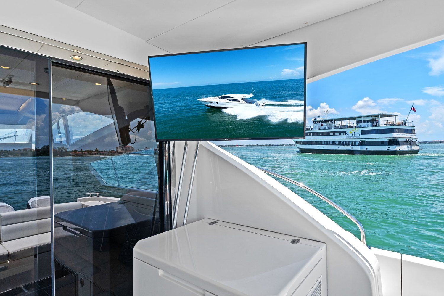 A luxurious catamaran with a modern interior and a TV displaying a boat on the water.