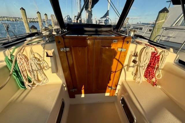 Cockpit of 1999 Caliber 40LRC sailboat with ropes and wooden hatch.