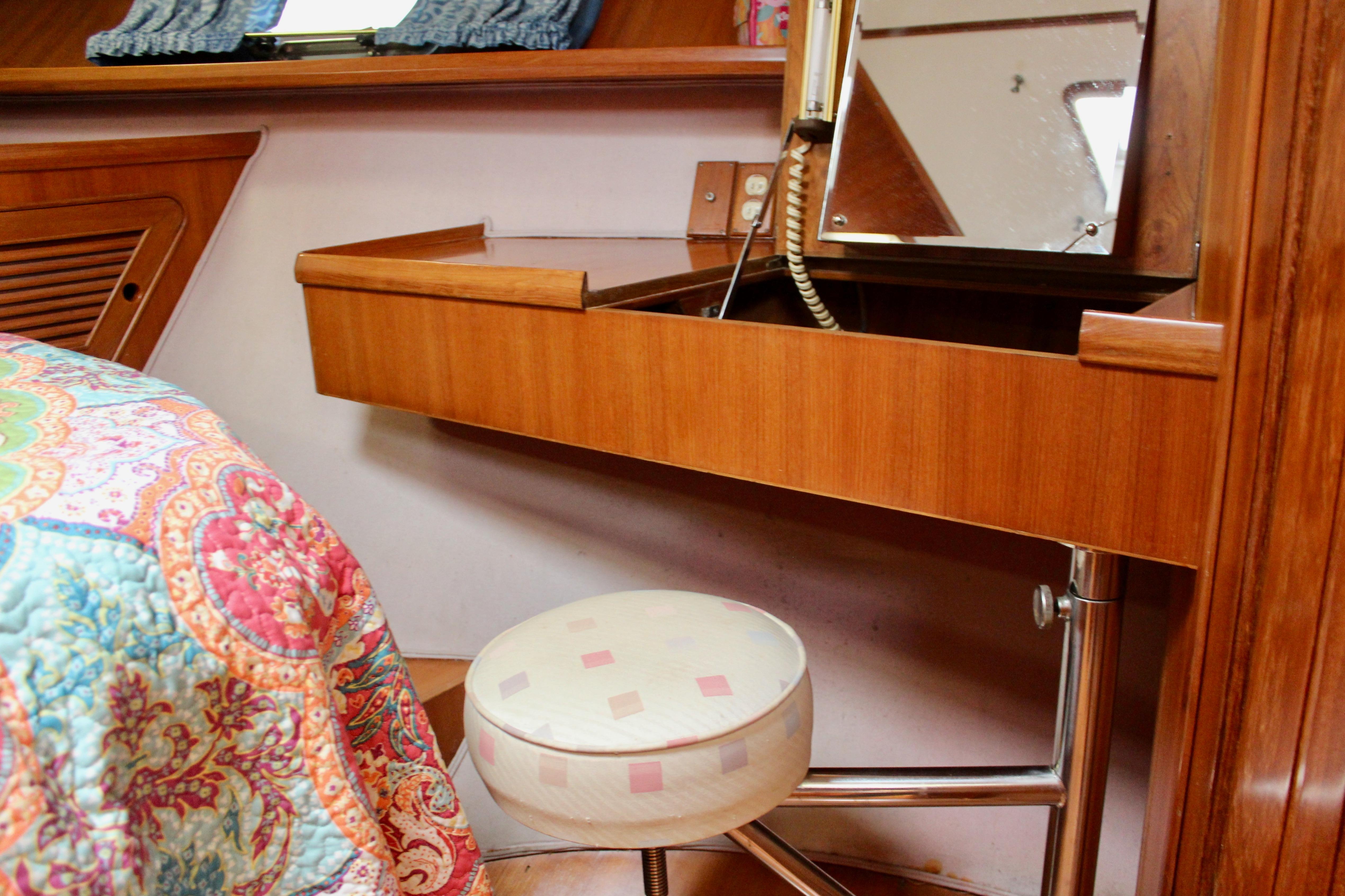 Interior of 1986 Kha Shing Spindrift 46 yacht with wooden vanity and colorful quilt.