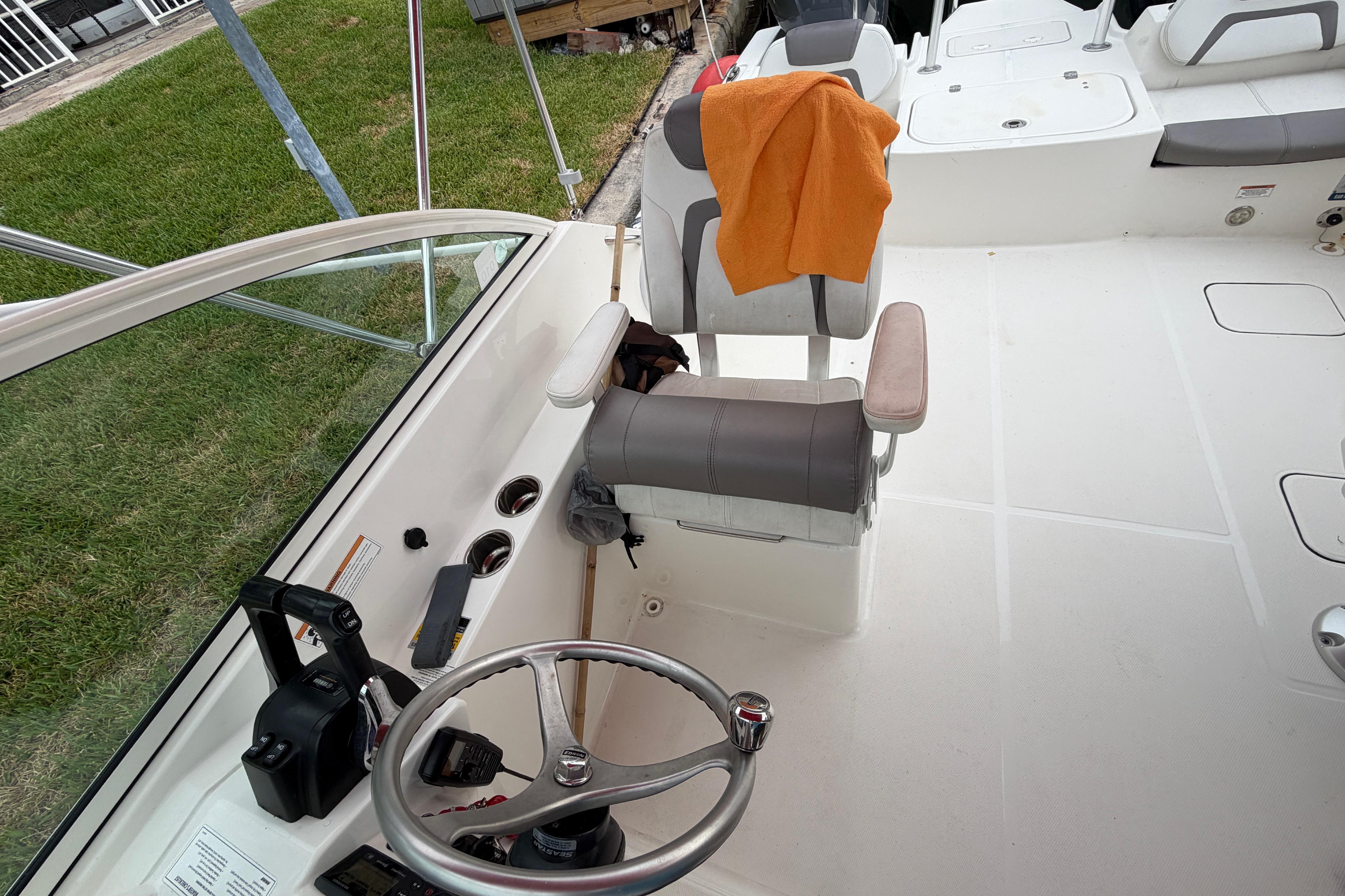 2019 World Cat 230 DC boat interior with steering wheel and seating area.