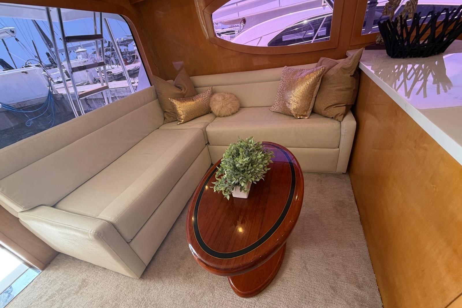 Luxurious interior of 2003 Hatteras 54 Convertible yacht with plush seating and elegant decor.