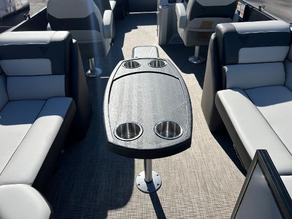 Interior of a 2023 Viaggio Lago 22U Tri Toon with gray seating and table.